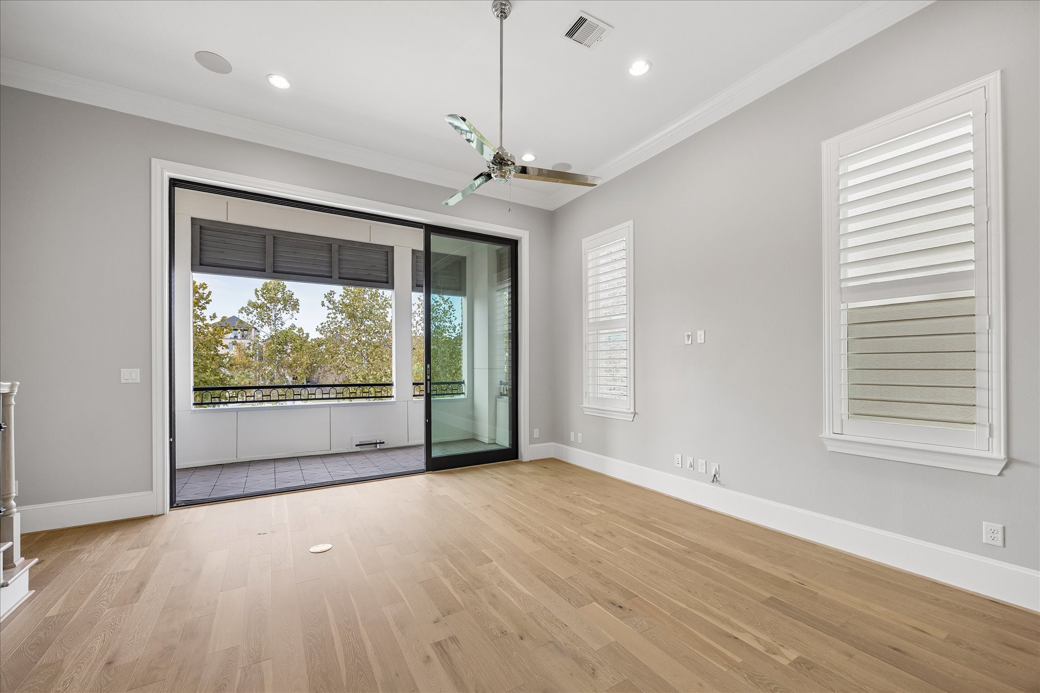 Bright, open living space with sleek hardwood floors and large sliding doors leading to a balcony with scenic views of Lake and fountain.  The sliding glass doors are 3 panels that open wide on cool days. .