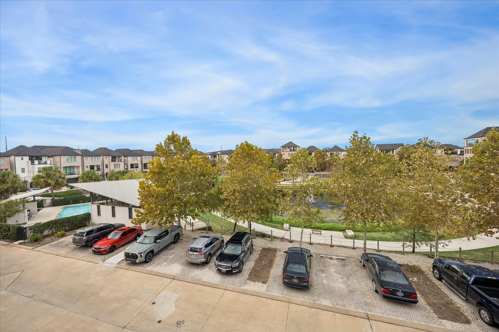 Enjoy serene views of a landscaped pond and community pool, surrounded by charming townhouses and ample parking.