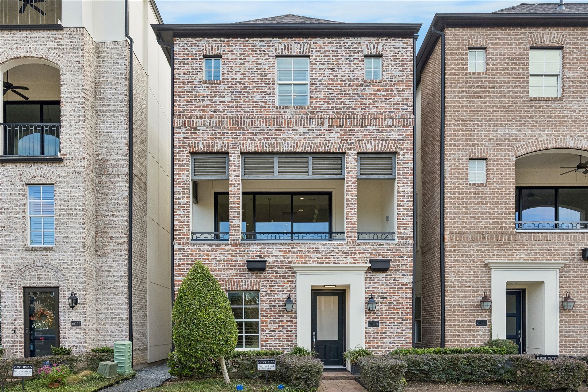 Elegant three-story single family home with classic brick facade and inviting balcony overlooking the community Lake and fountain for outdoor comfort and enjoyment.