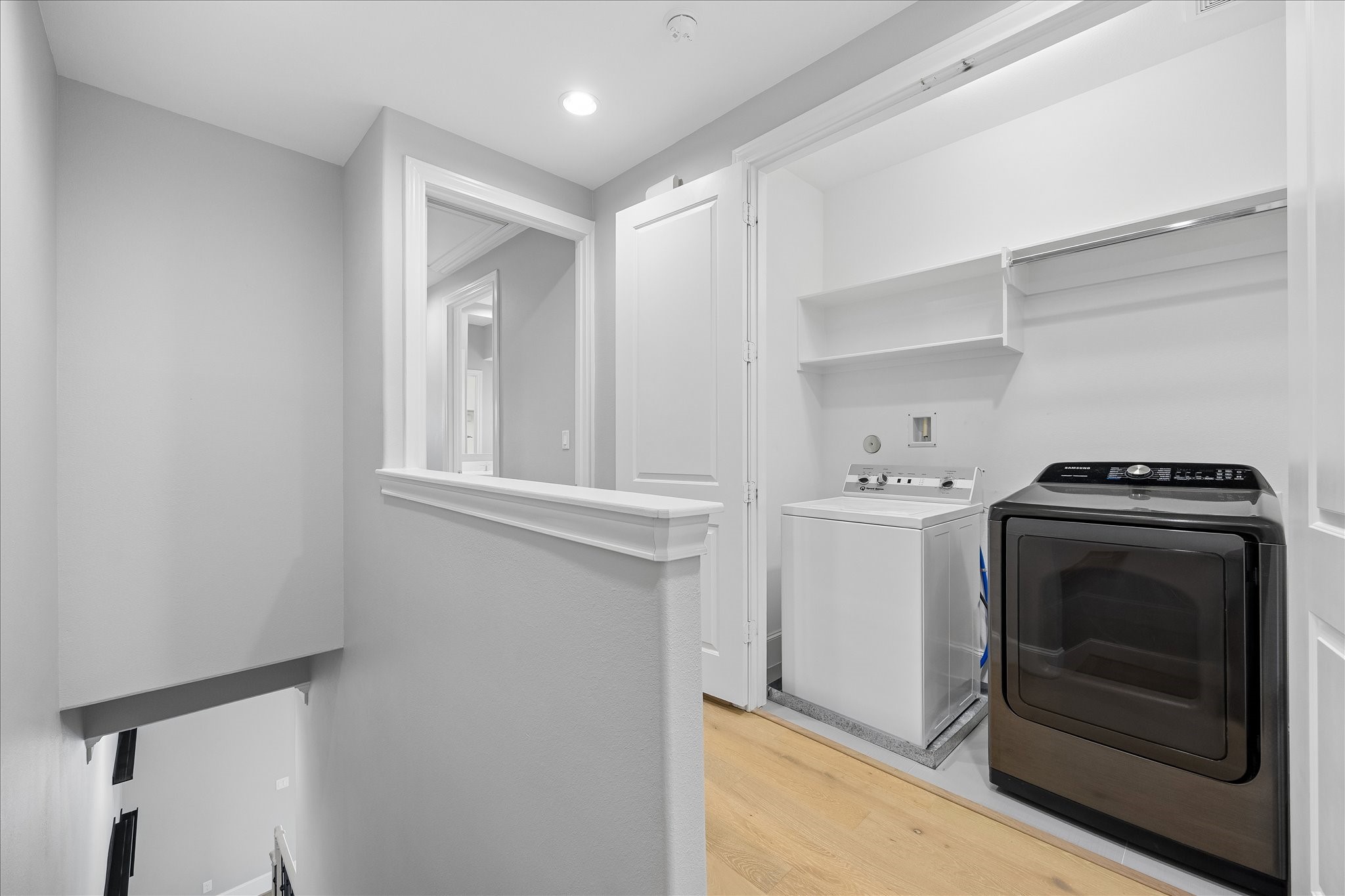 Convenient laundry area on the upper level, featuring a washer and dryer, with adjacent hallway access. Washer and dryer included in home purchase.  See description