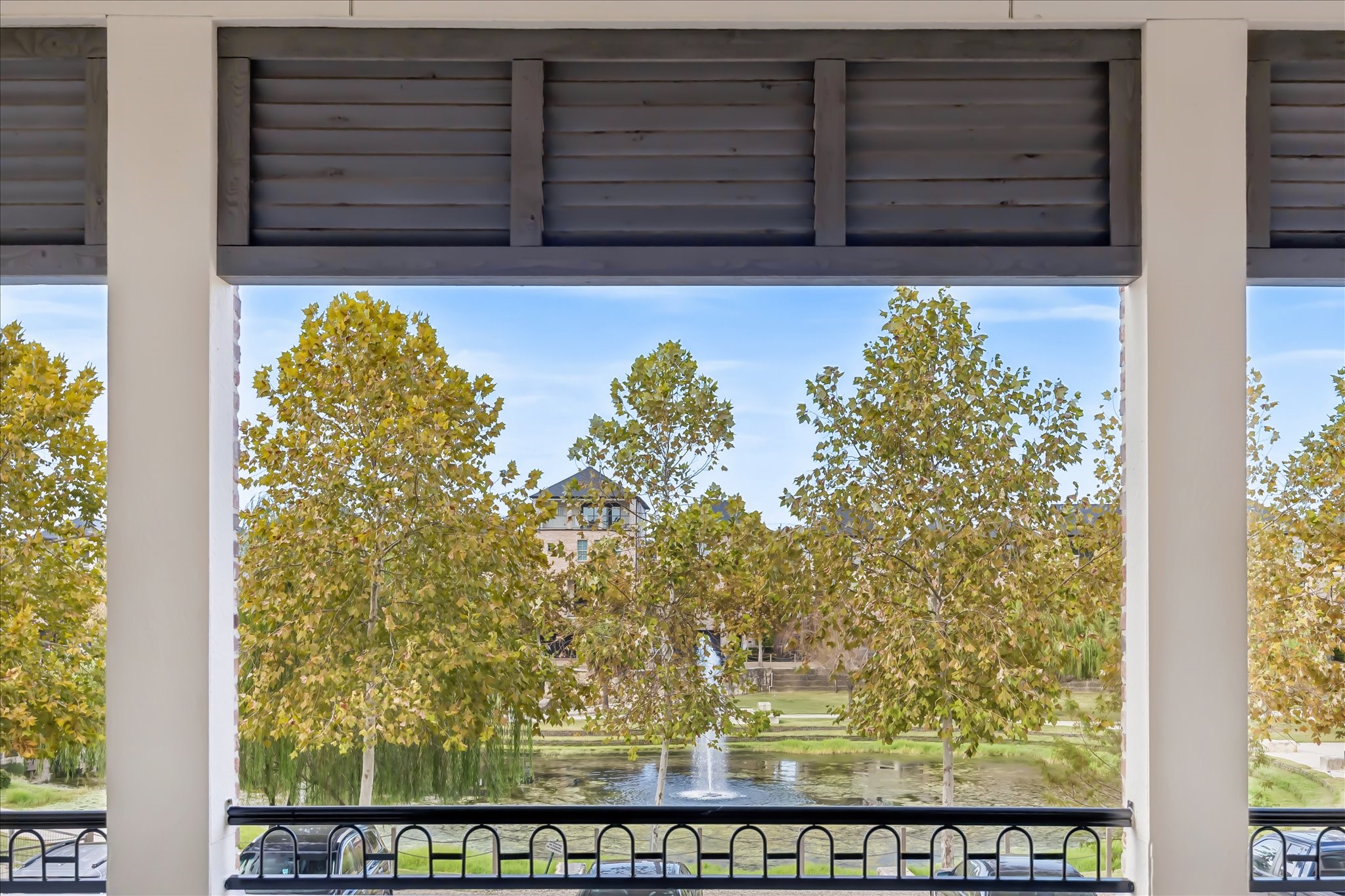 Enjoy serene views of lush trees and a tranquil pond with fountain water feature from the comfort of your spacious living area and balcony.