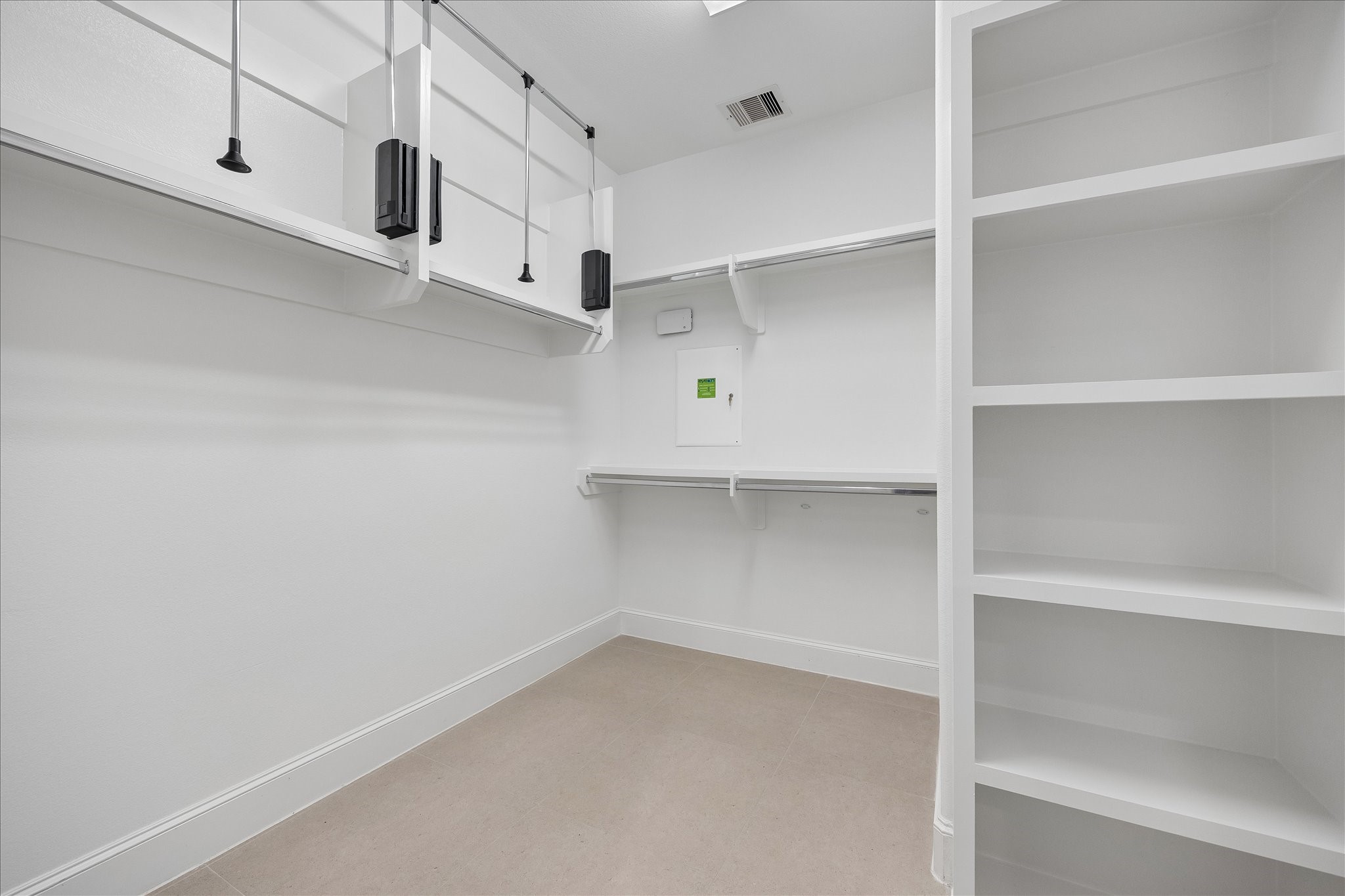 Spacious walk-in closet featuring built-in shelving and ample hanging space, perfect for organized storage.