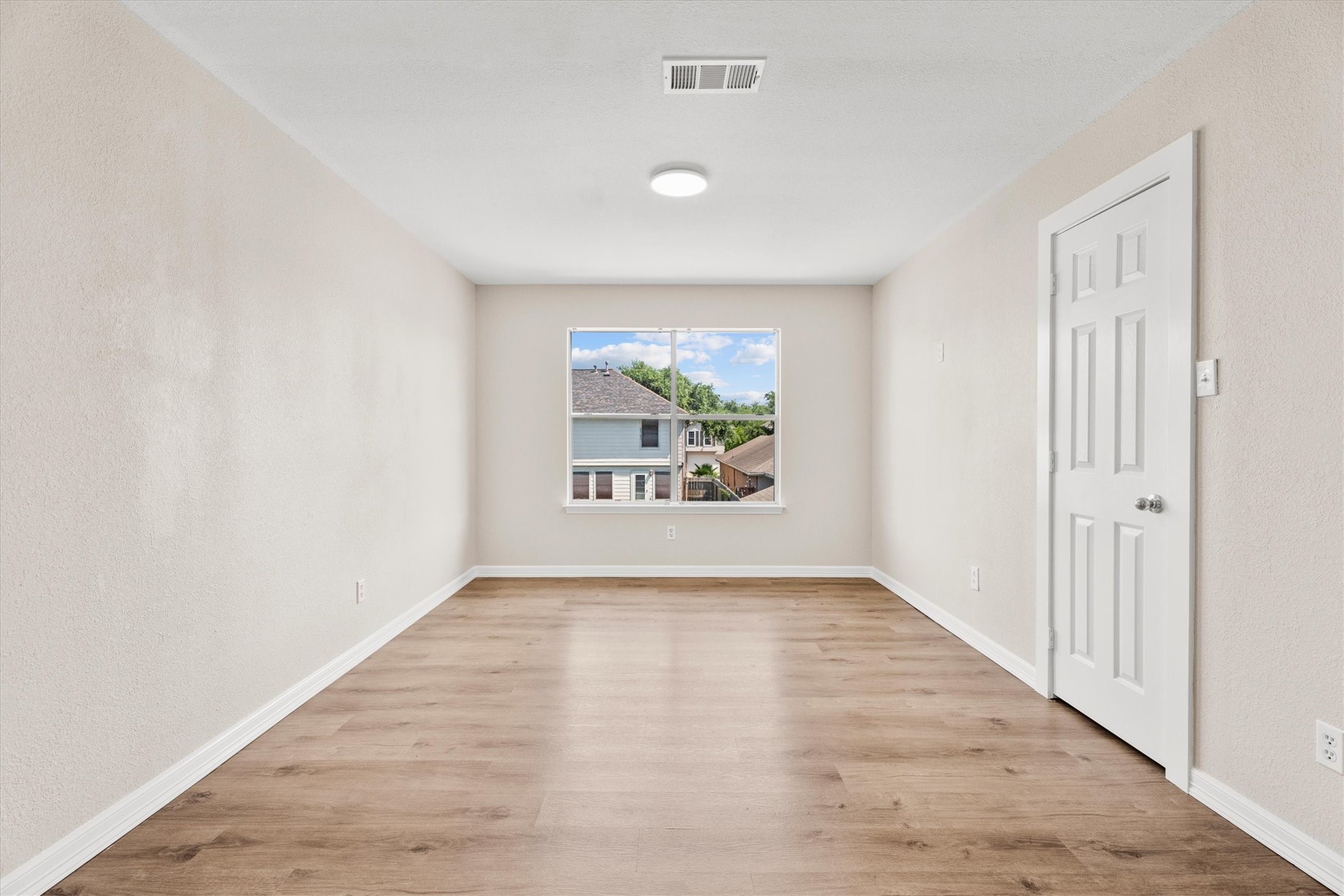 Versatile second-floor gameroom, loft, or flex space featuring durable flooring and a storage closet.