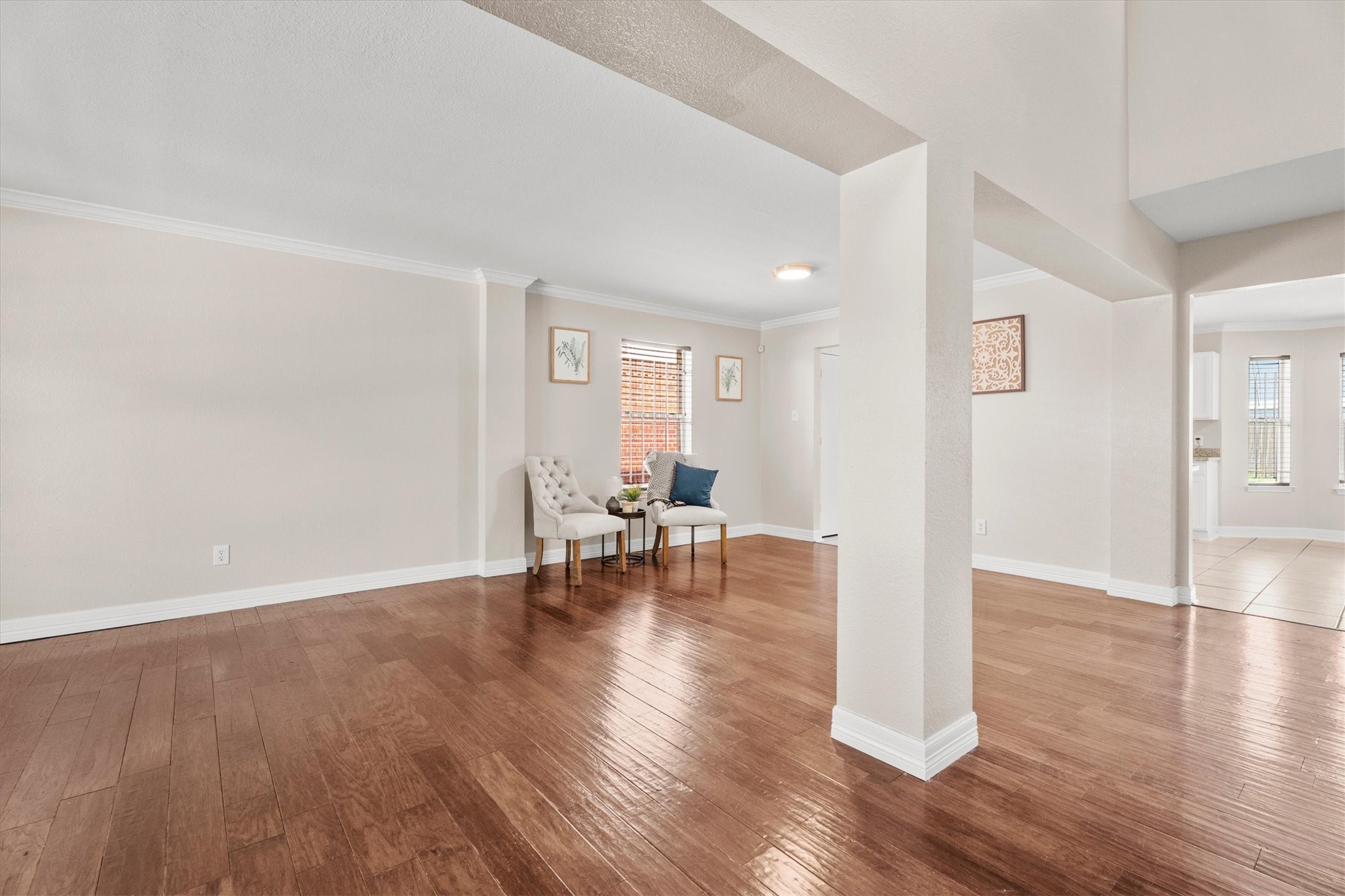 Open and inviting front living and formal dining areas featuring rich wood flooring and abundant natural light.