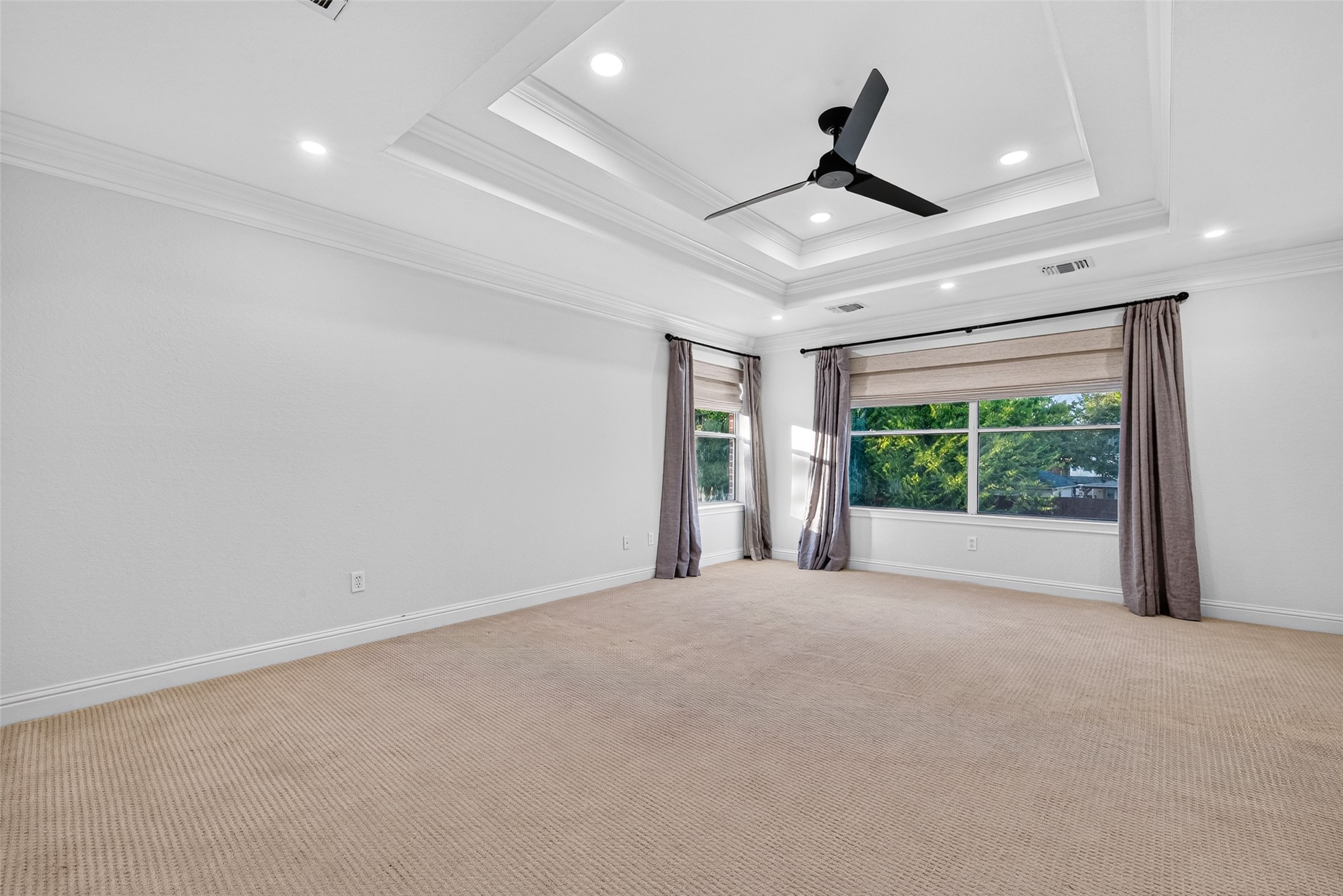A SPACIOUS PRIMARY RETREAT WITH AN INCREDIBLE VIEW! Located upstairs, this generously sized Primary Bedroom features an impressive tray ceiling with decorative crown molding, recessed lighting & a contemporary ceiling fan. Large windows with woven blinds overlook the sparkling pool & beautifully landscaped backyard, creating a wonderful backdrop for everyday living. With plenty of room for a king-size bed, additional furnishings & a comfortable sitting area, this inviting retreat offers the perfect place to