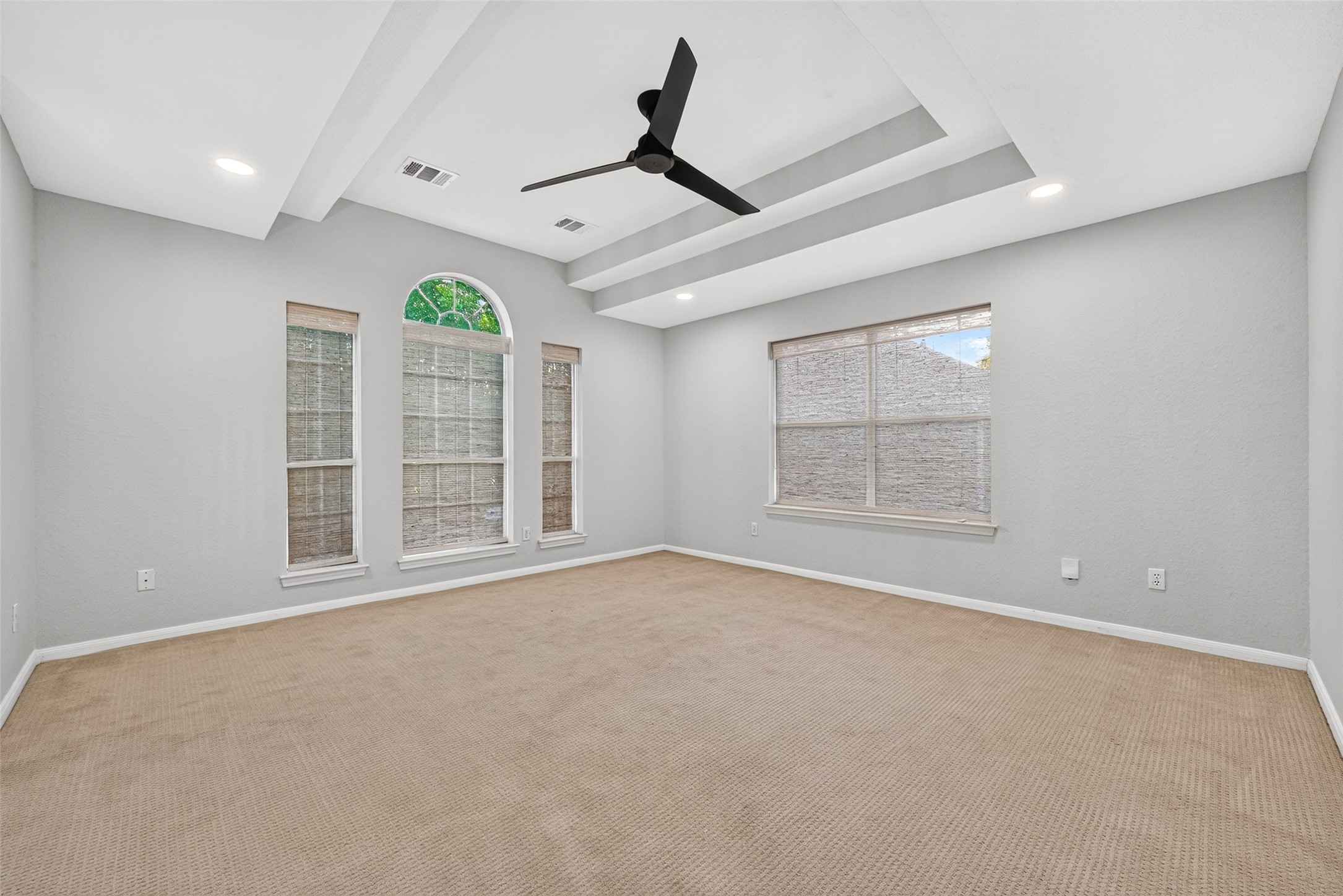 ROOM TO PLAY, RELAX & UNWIND! The spacious upstairs Game Room features a distinctive tray ceiling, contemporary ceiling fan, recessed lighting & windows with attractive woven blinds. The beautiful arched window adds architectural character, while the generous floor space offers flexibility for a media room, children's playroom or comfortable second living area. Whether it's movie night, watching the big game or simply relaxing, this inviting space is ready to enjoy.