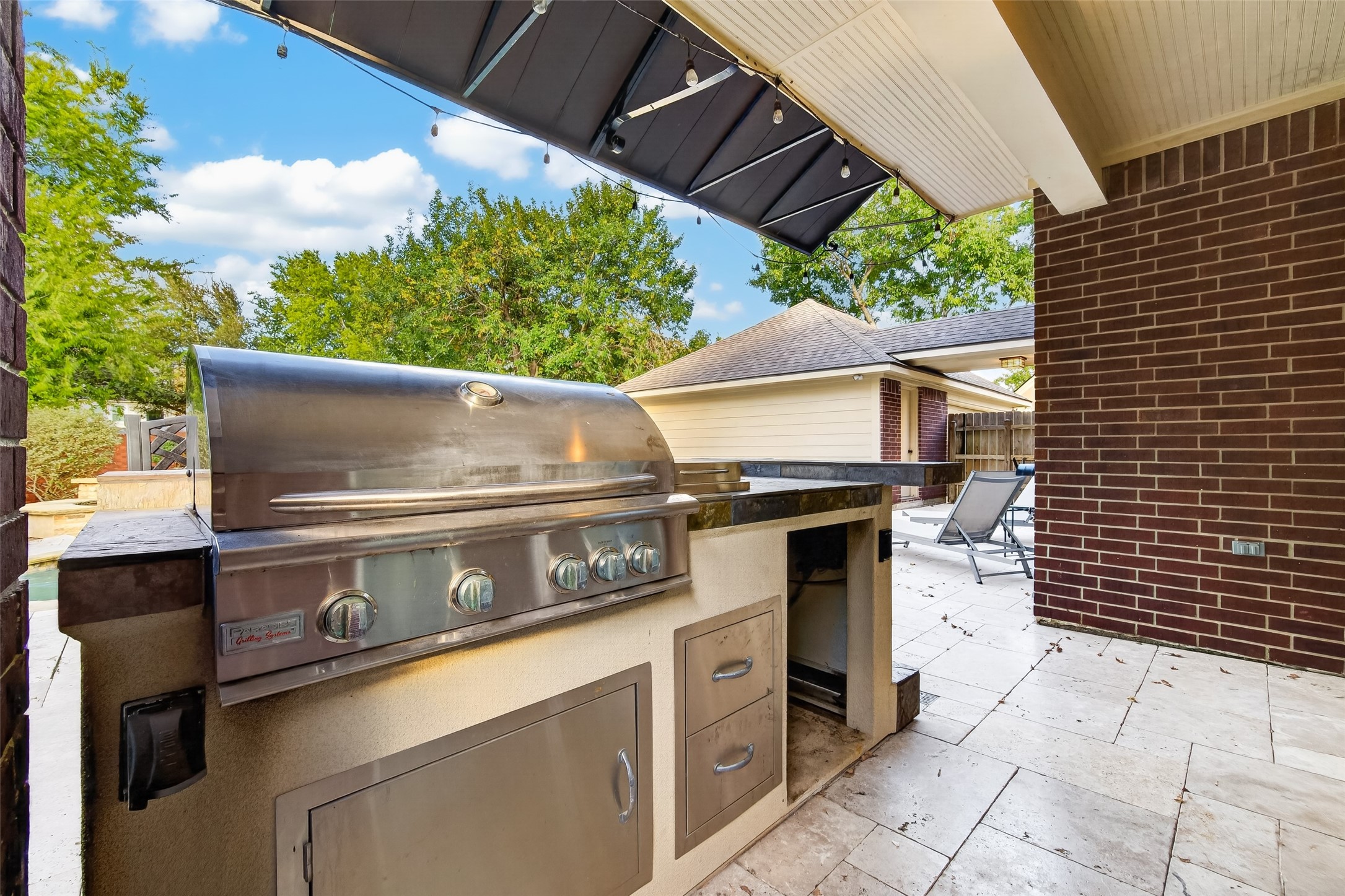 OUTDOOR COOKING JUST GOT MORE ENJOYABLE! This built-in gas grill makes preparing meals outdoors a pleasure, with generous countertop space for food preparation & serving, plus built-in storage below. The copper awning provides welcome shade over the cooking area, while the surrounding Travertine decking connects this outdoor kitchen to the poolside entertaining areas. Imagine grilling your favorite steaks while enjoying a beautiful Houston evening!