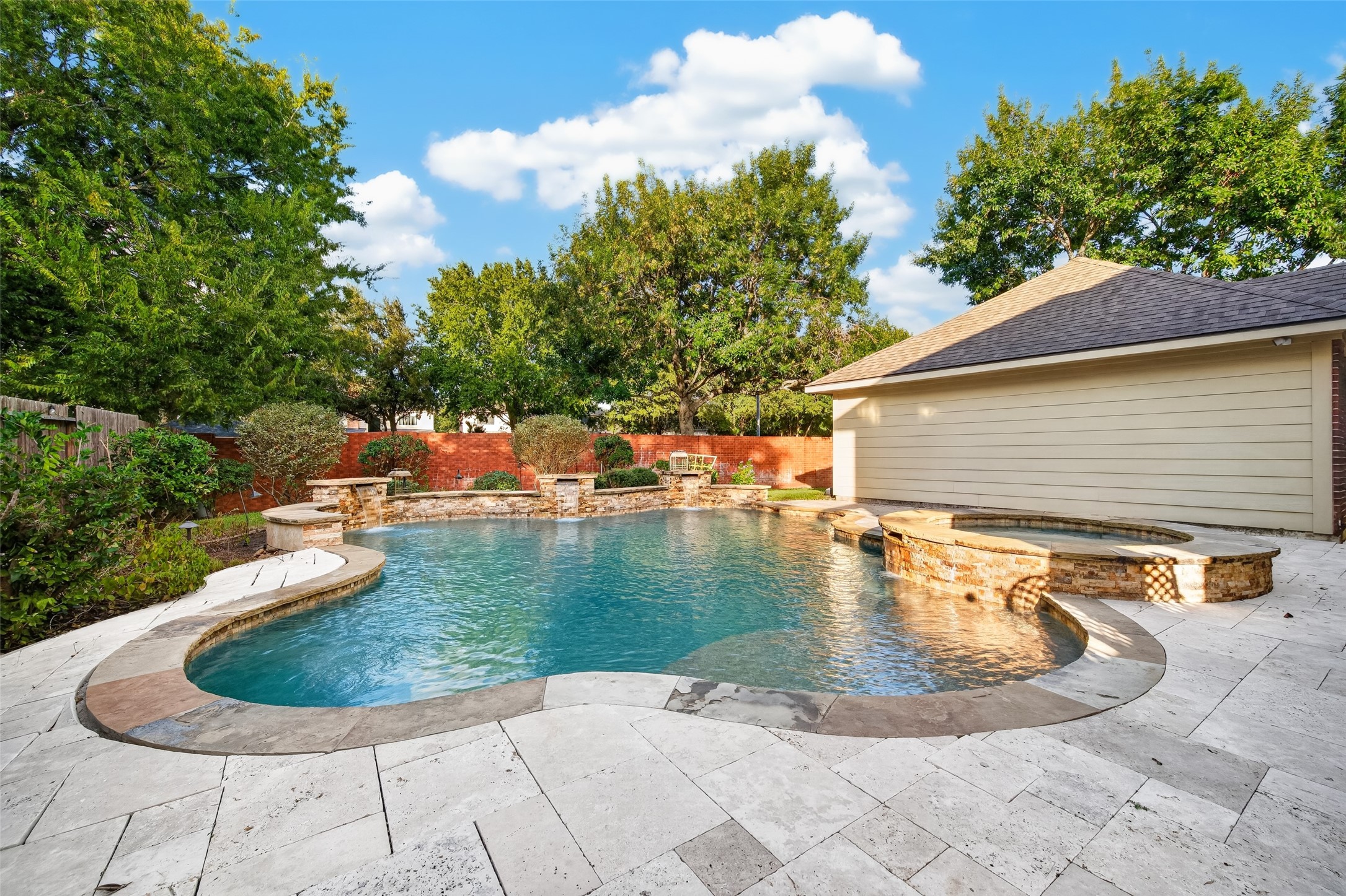 ROOM TO RELAX, ENTERTAIN & PLAY! Expansive Travertine decking surrounds the pool & spa, providing plenty of space for lounge chairs, outdoor furniture & gatherings with friends. And there's still grassy lawn space behind the pool & garage for your four-legged friends to run and play! Whether enjoying a quiet afternoon in the sunshine or hosting a weekend pool party, this backyard offers something for everyone.