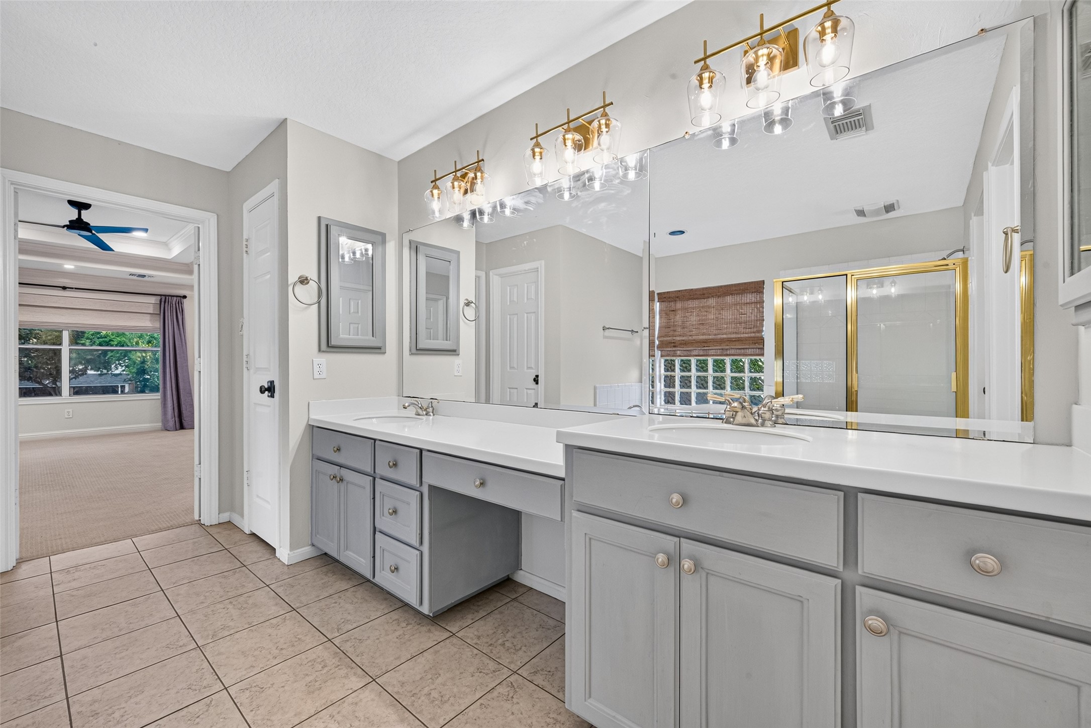 ROOM FOR TWO TO GET READY! The spacious Primary Bath features separate vanity areas with generous countertops, individual sinks, large mirrors & ample cabinetry for everyday essentials. Decorative light fixtures brighten each vanity, while a linen closet provides additional storage for towels & toiletries. A private water closet adds another level of convenience, making busy mornings a little easier.
