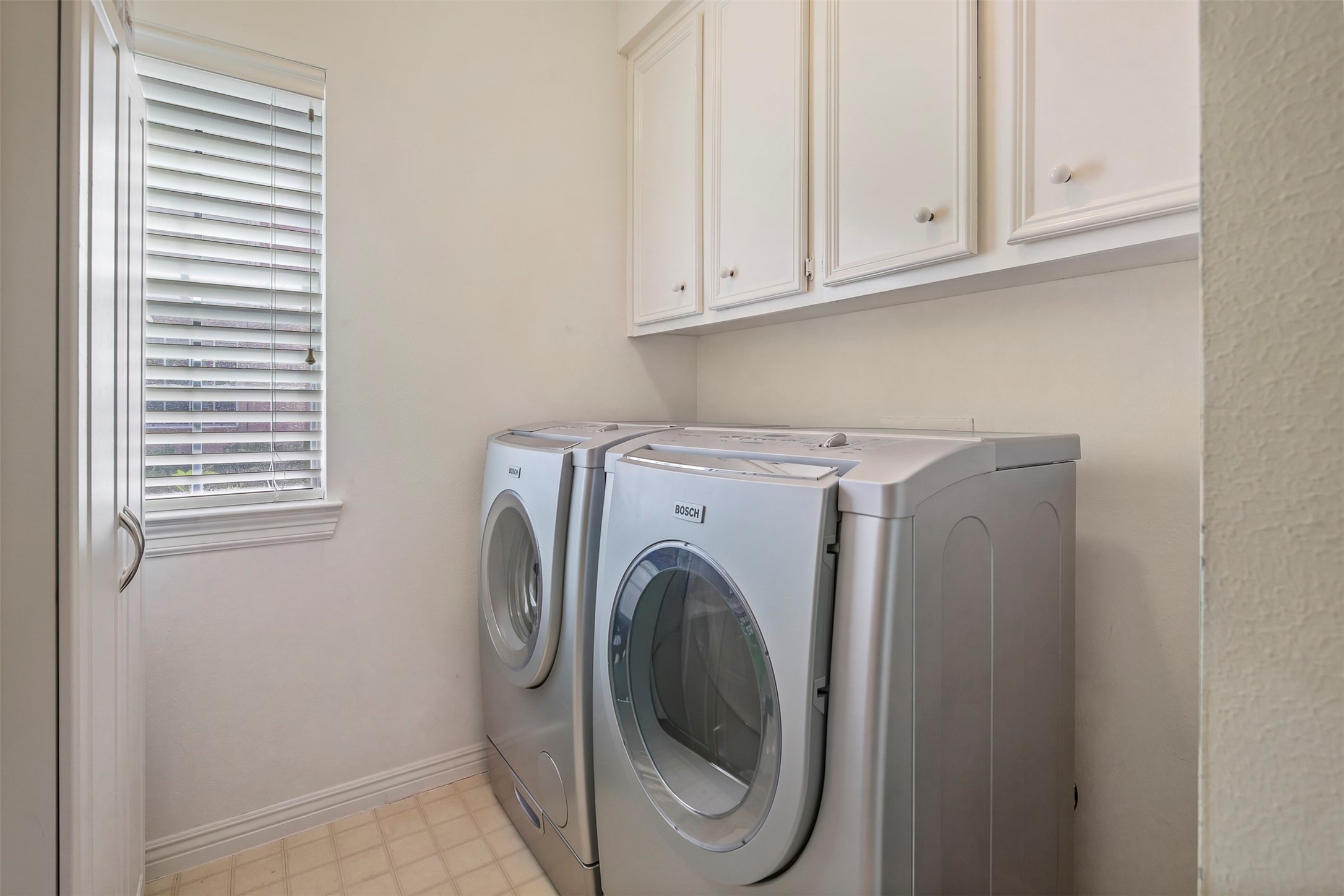 Utility room features built in cabinets for extra storage.