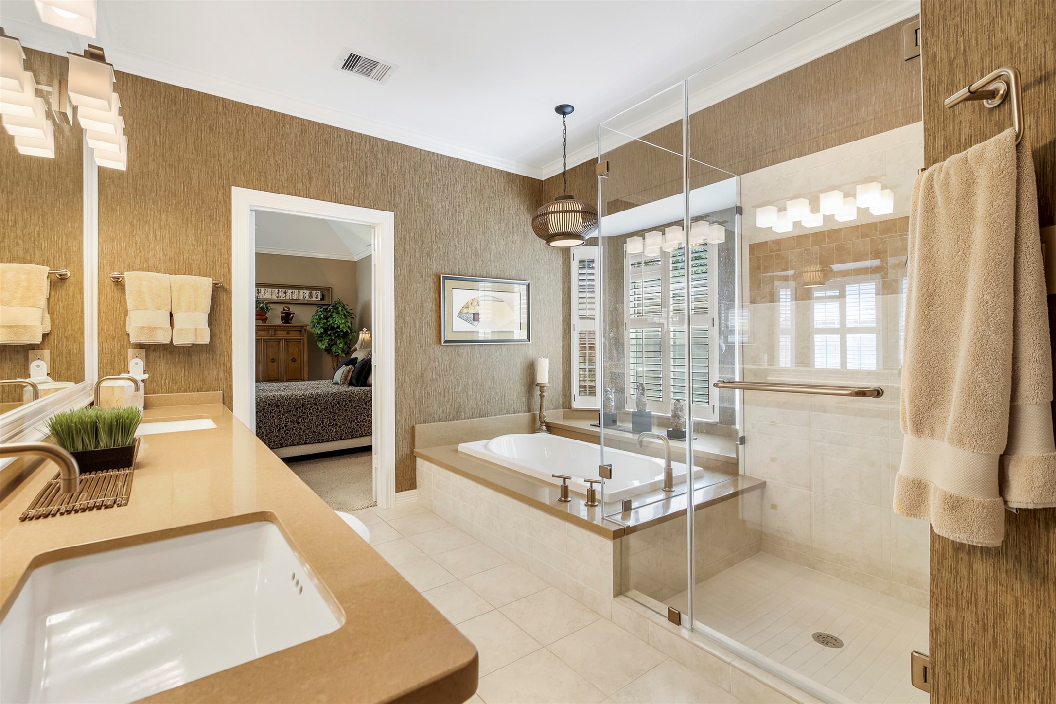 The primary bathroom features a separate soaking tub with quartz surround, and large frameless glass walk in shower with bench seat.