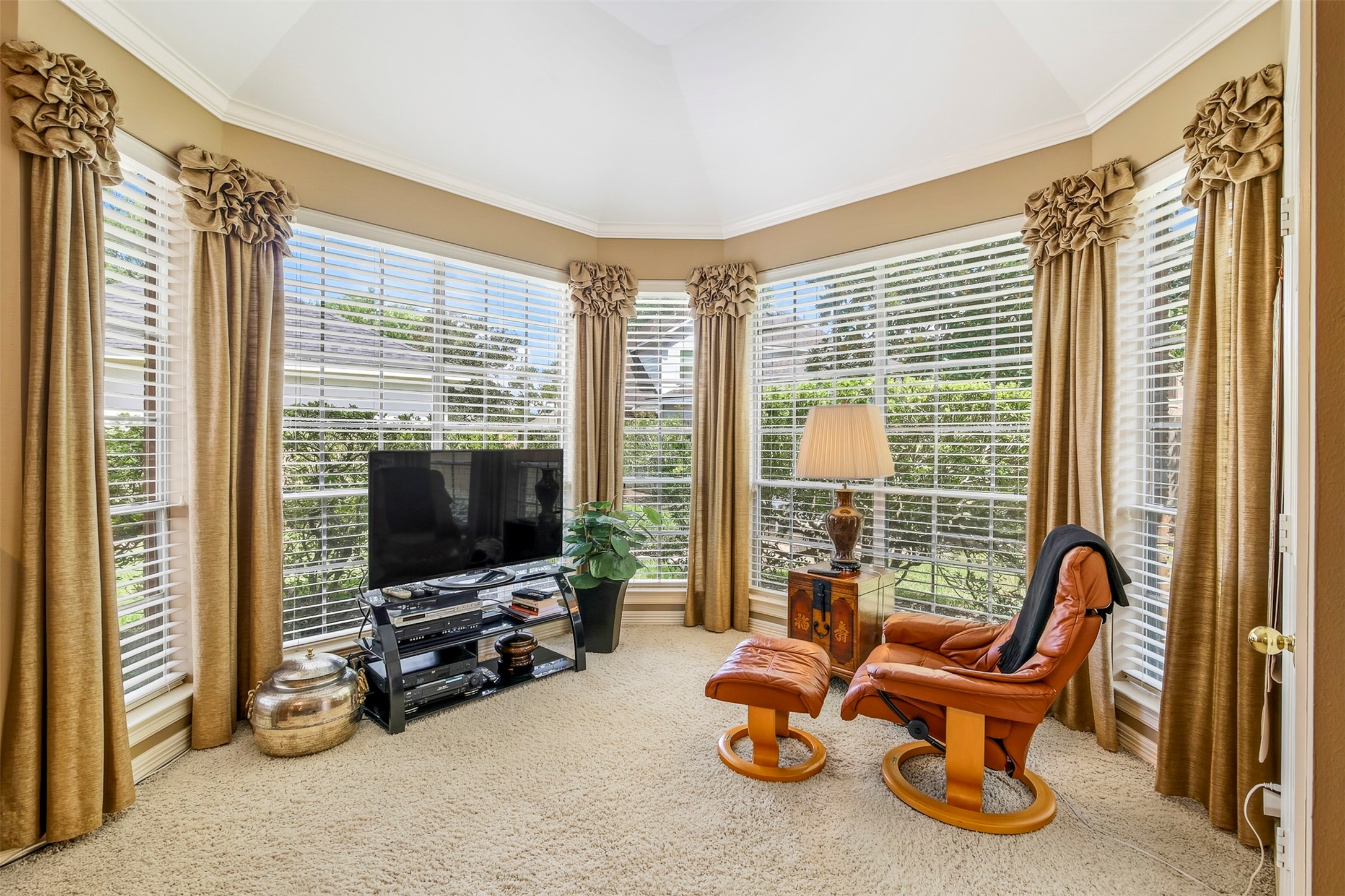 View of the sitting area encompassed with floor to ceiling windows looking out into the backyard.