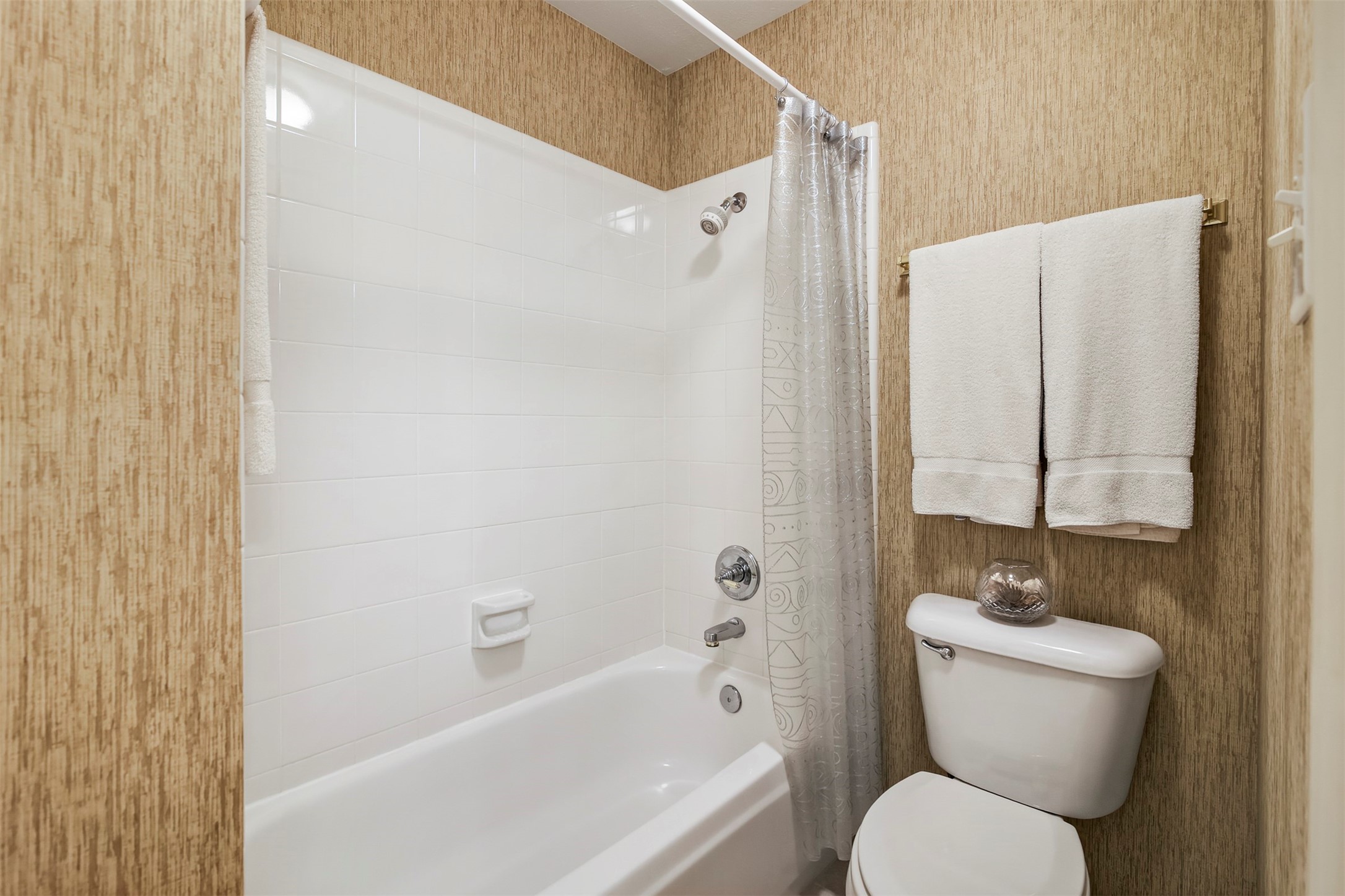 Tub and shower combo located in the shared secondary full bathroom.