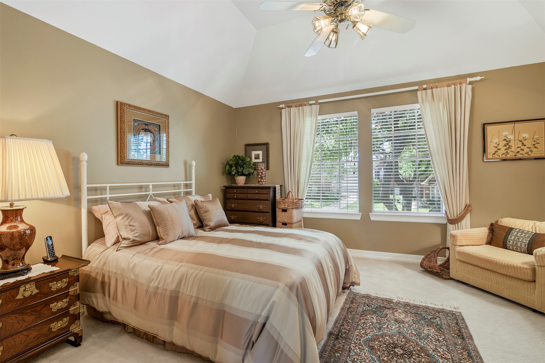 Spacious secondary bedroom upstairs features carpet, large picture windows and ceiling fan.