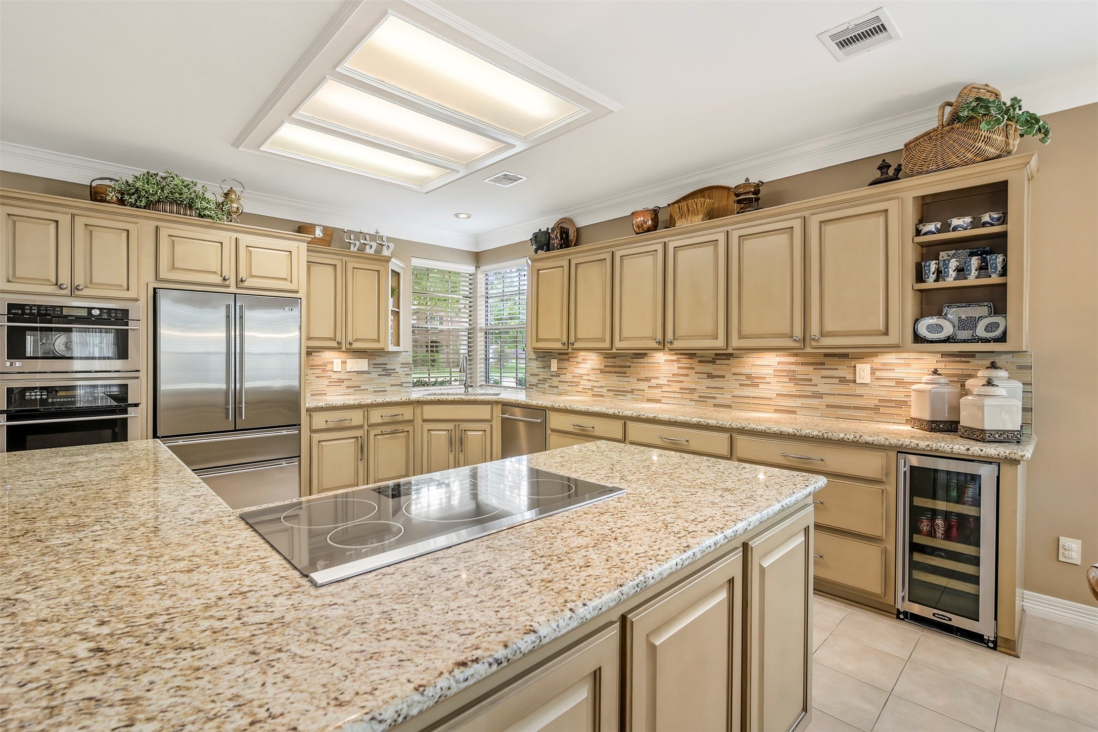 The spacious updated kitchen is ready for its next chef. The kitchen features granite countertops with tile backsplash. There are custom cabinets for plenty of storage space to include pots and pans drawers as well as under cabinet lighting.