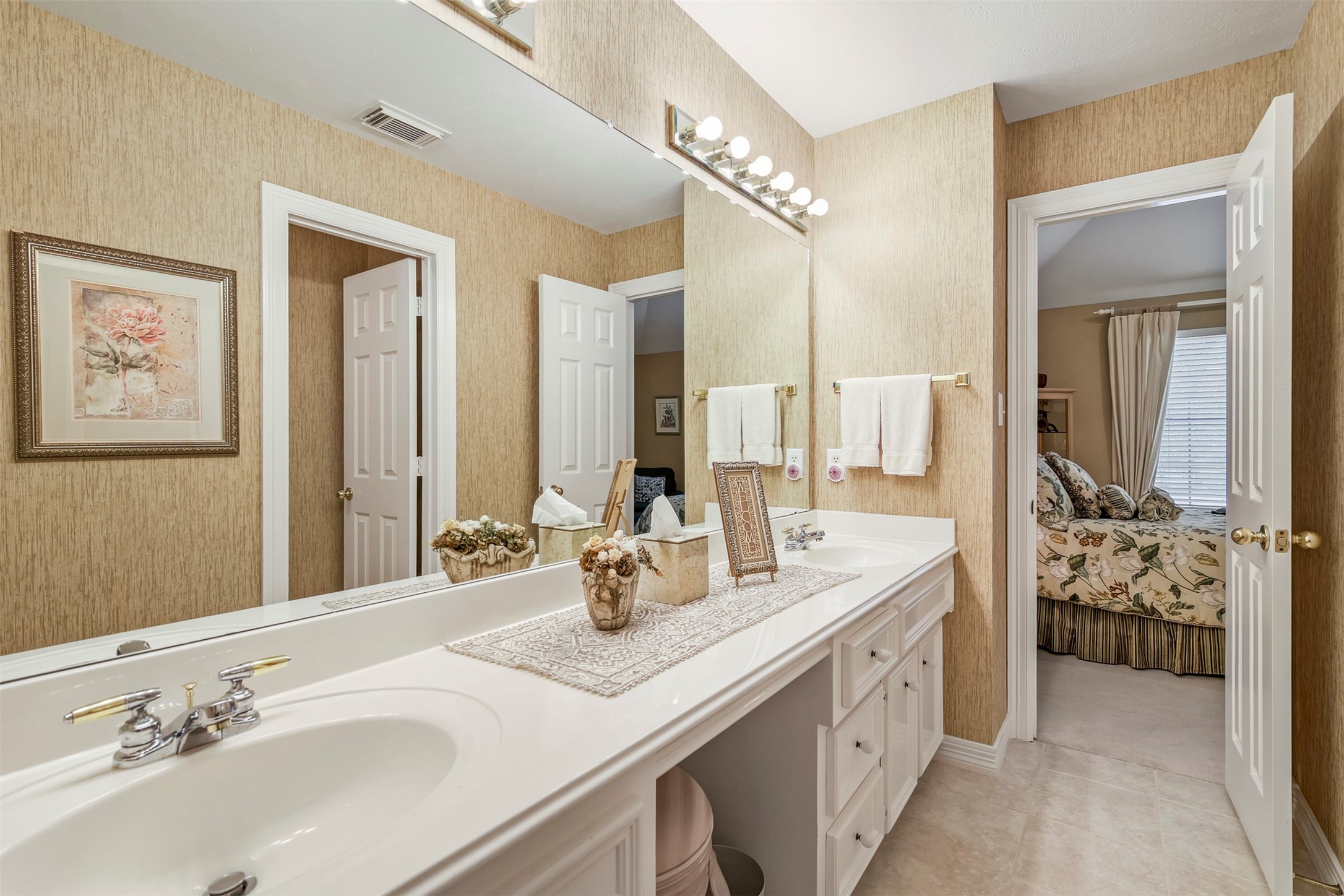 View of the secondary full bathroom upstairs with double sinks and knee space vanity.