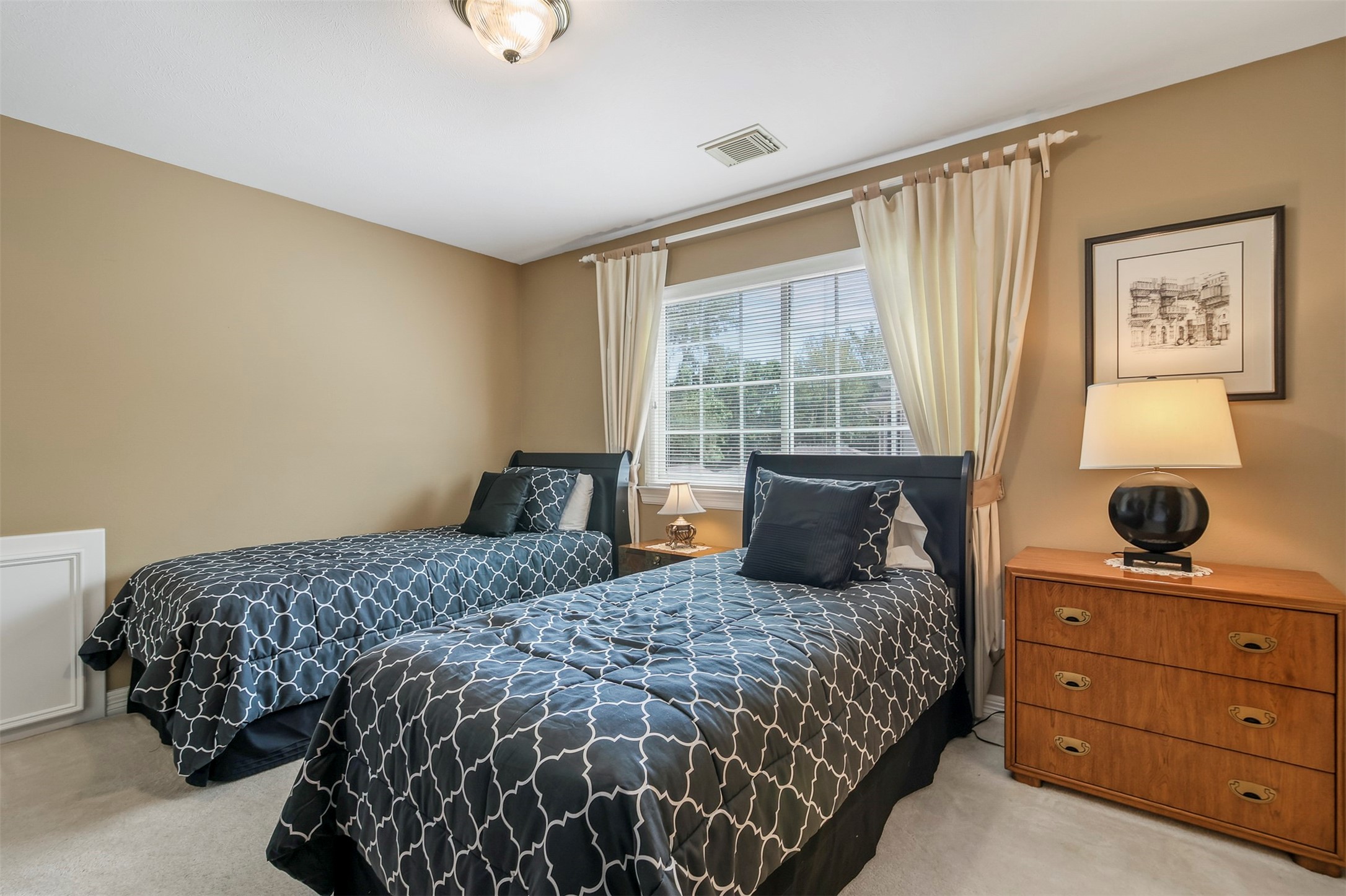 Another secondary bedroom with carpet and large picture window as well as access to ensuite shared bathroom.