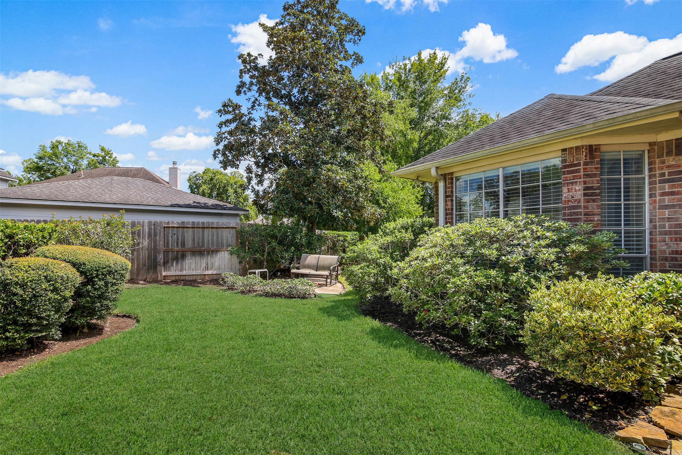 View of the well maintained and professionally landscaped backyard with sitting area. *Grass has been virtually enhanced*