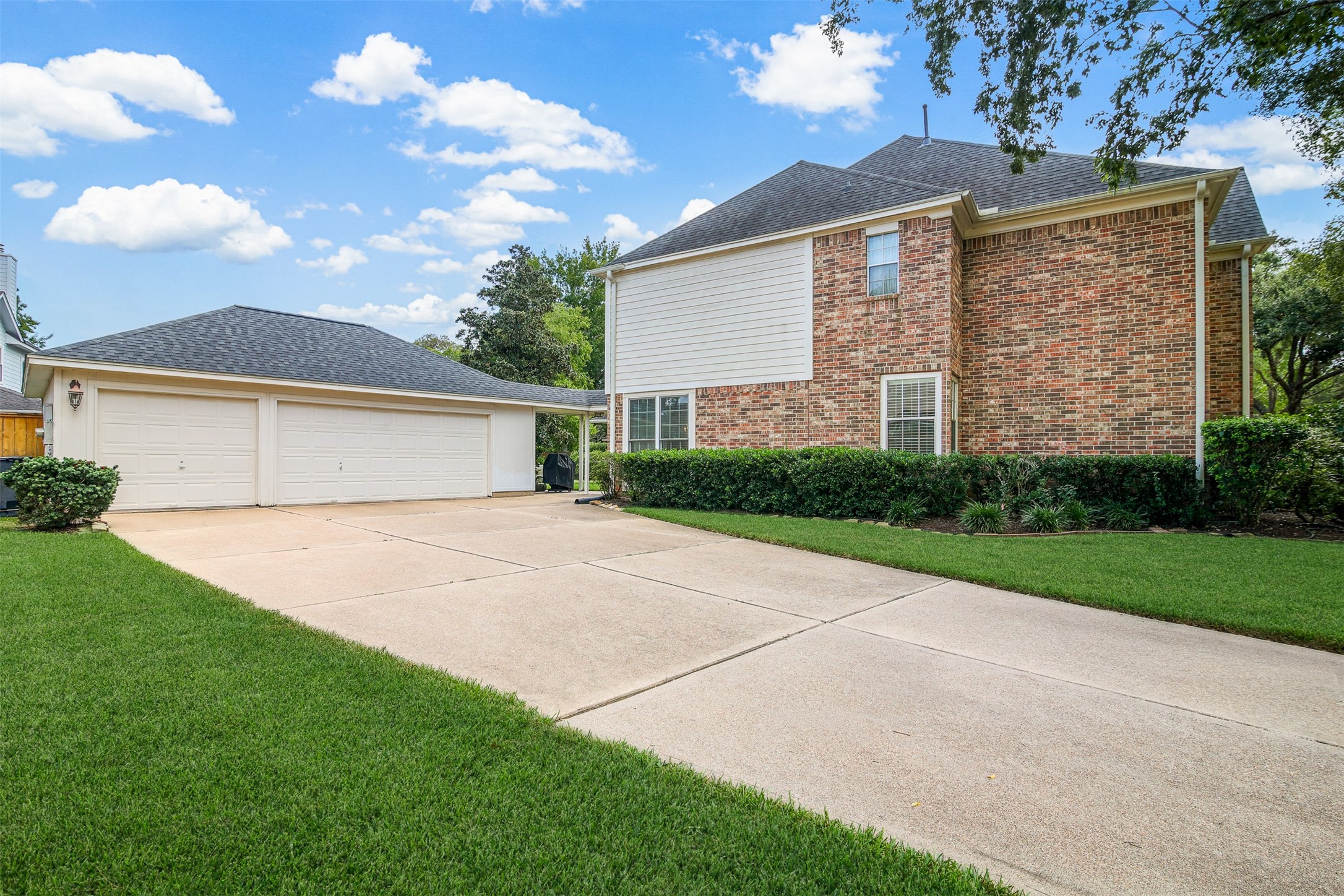 View of the large double driveway with 3 car detached garaged. *Grass has been virtually enhanced*