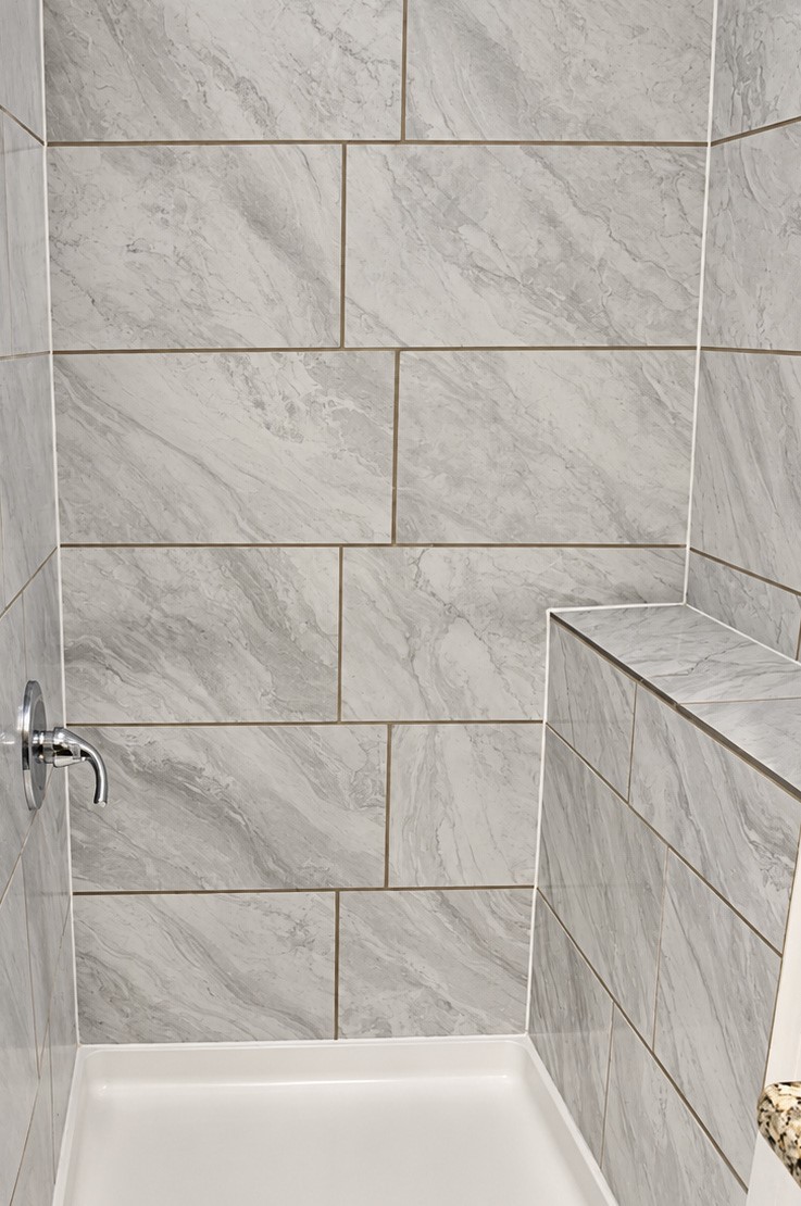 Quarters' shower with sleek, large-format marble tile.