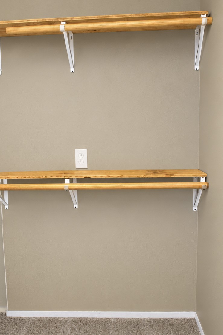 Cozy closet space featuring rustic dual wooden shelves.