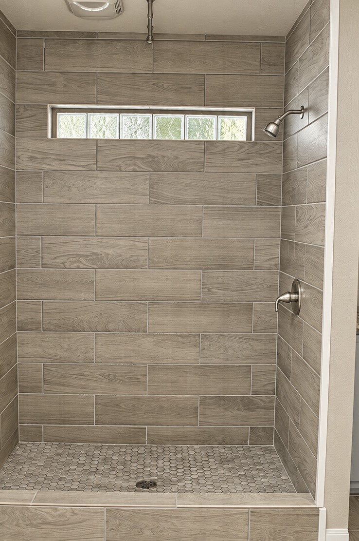 Elegant walk-in shower in Primary Bath featuring modern gray tile.