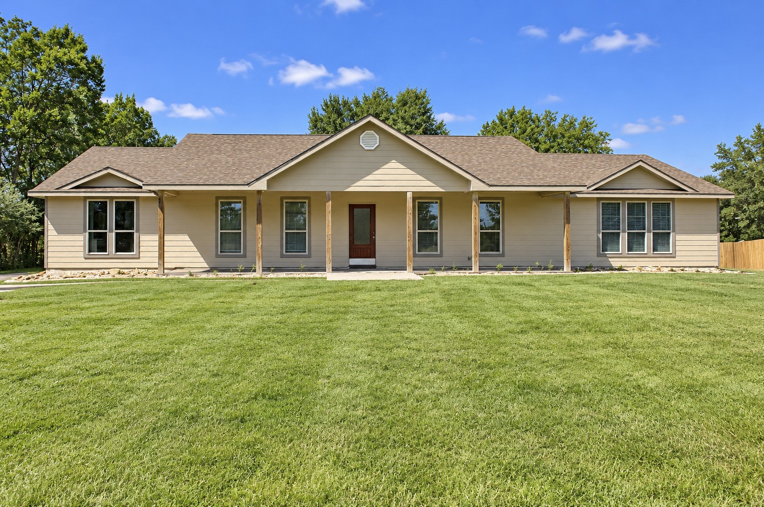 Charming ranch-style home with a welcoming front porch, nestled on a spacious acreage.
