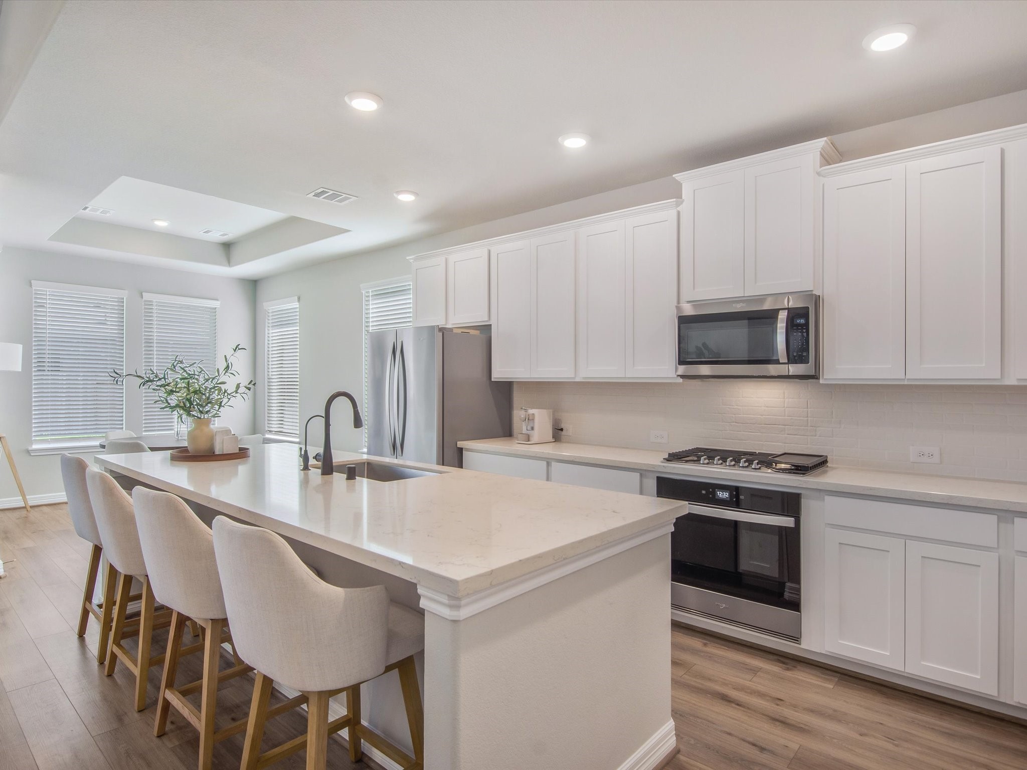 Kitchen with quartz countertops, 42" shaker style cabinets, lightly used appliances.