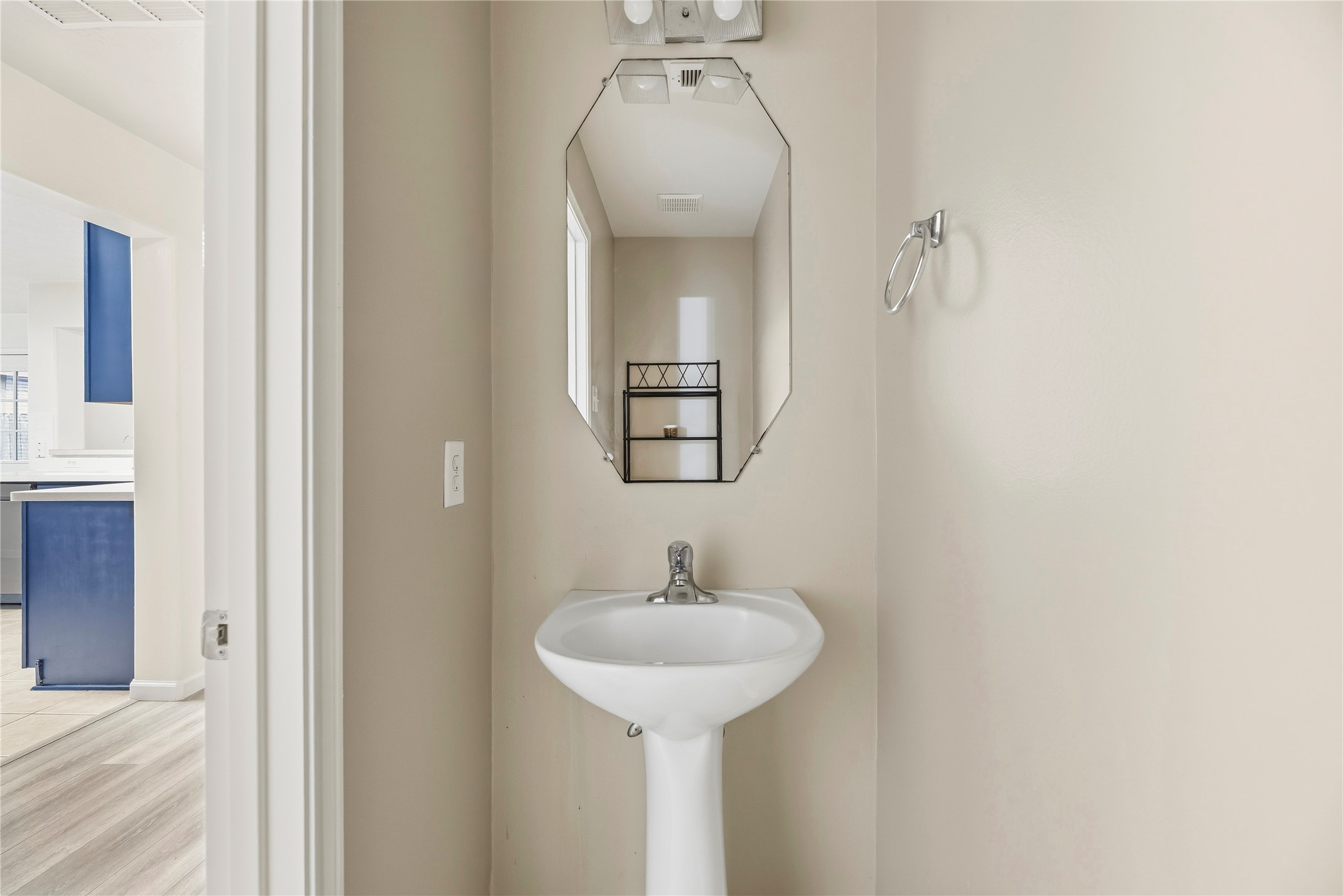 Convenient downstairs half bathroom with a pedestal sink.