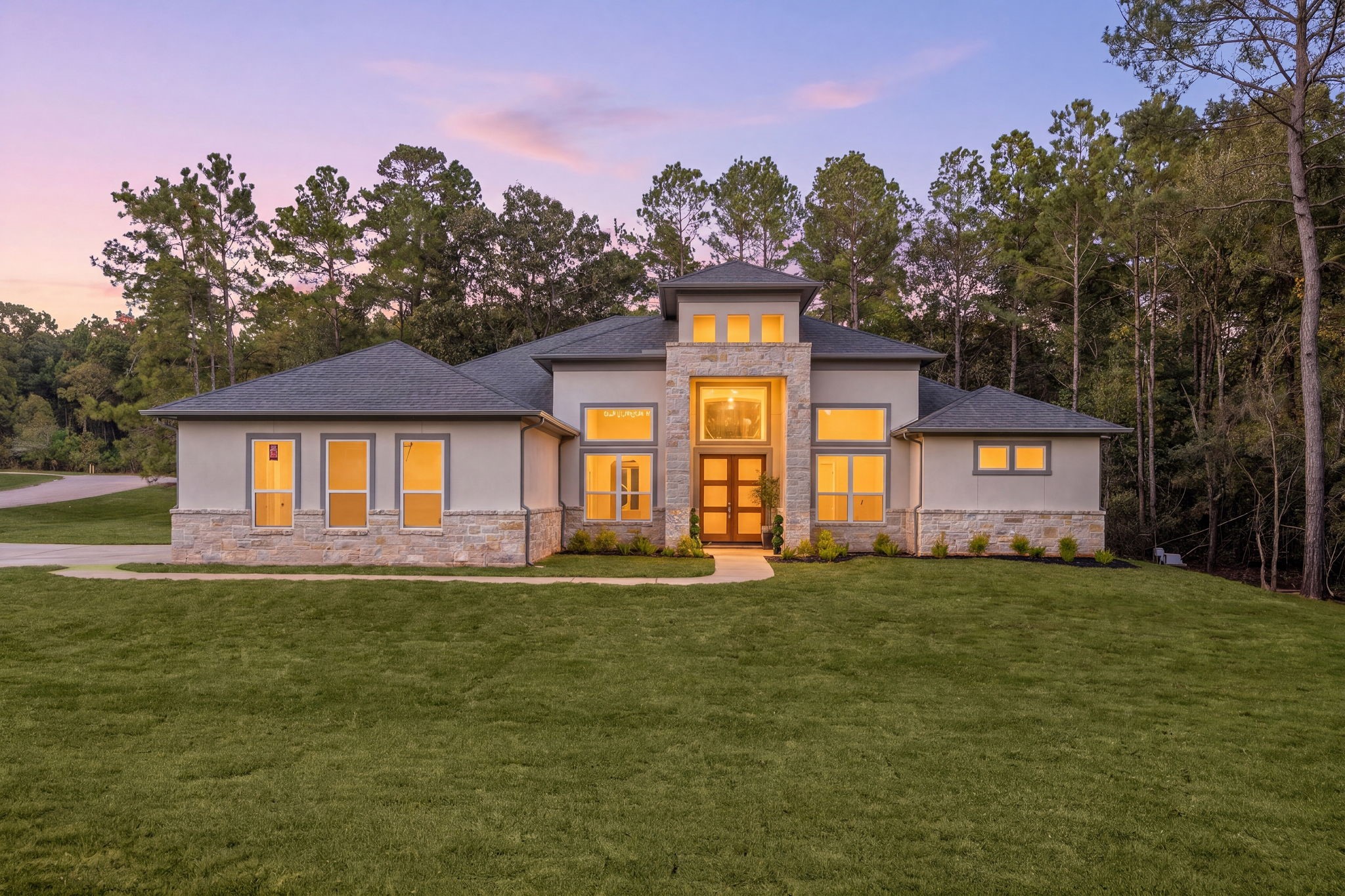 Stunning contemporary estate showcasing sophisticated architecture, elegant exterior lighting, and a beautifully landscaped setting.