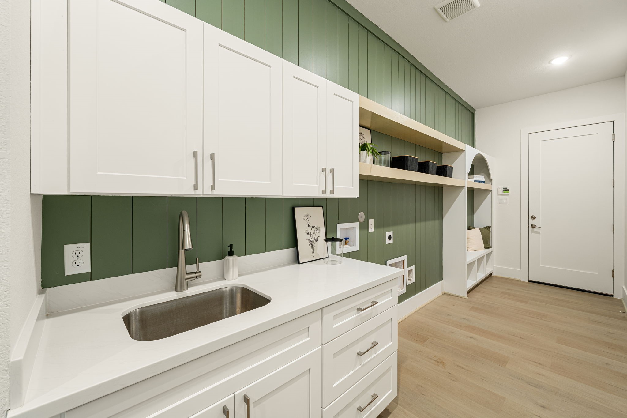 Spacious utility room featuring abundant cabinetry, countertop space, and built-in storage.