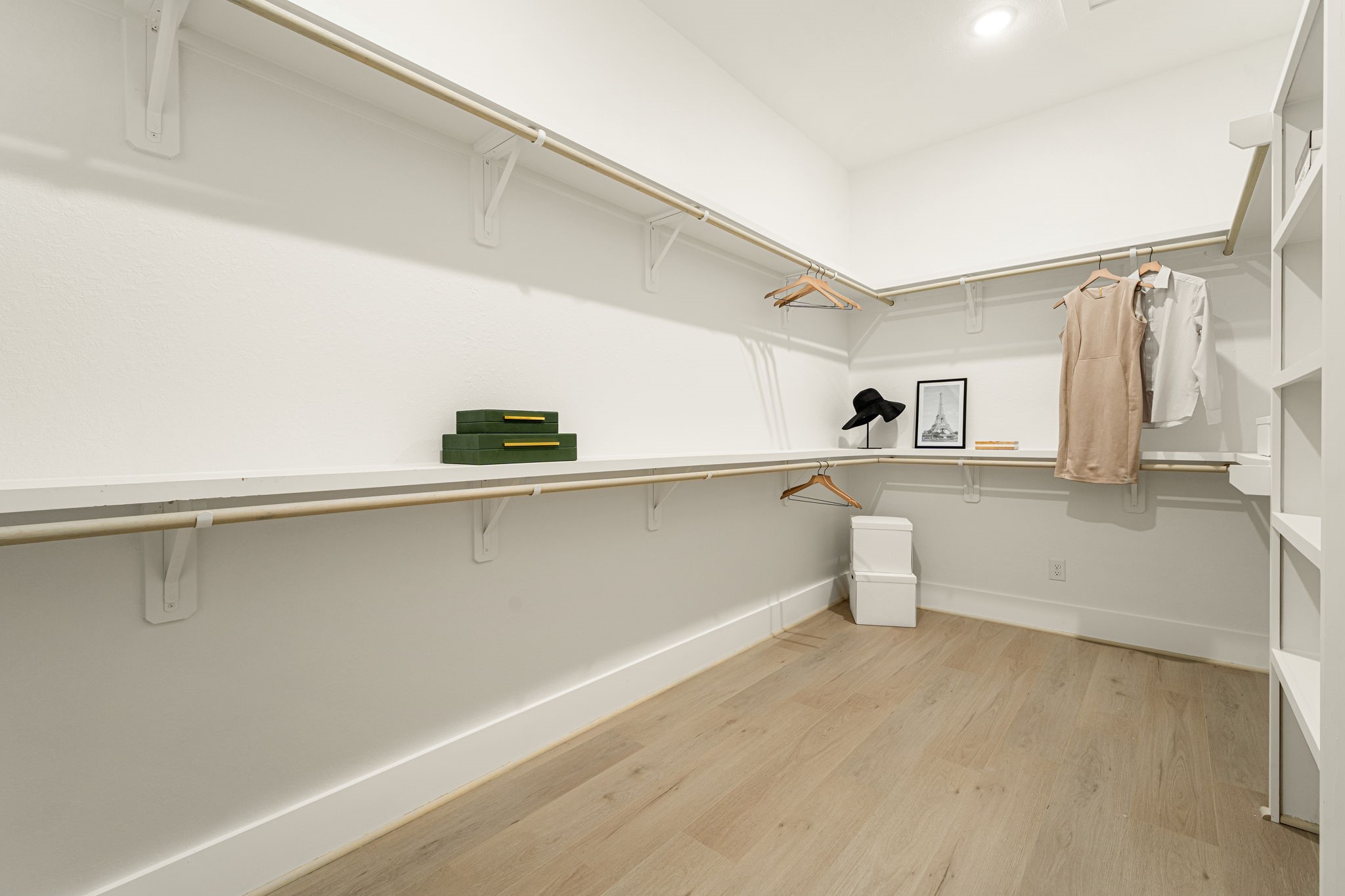 Spacious primary closet featuring extensive built-in shelving, hanging space, and custom organization.