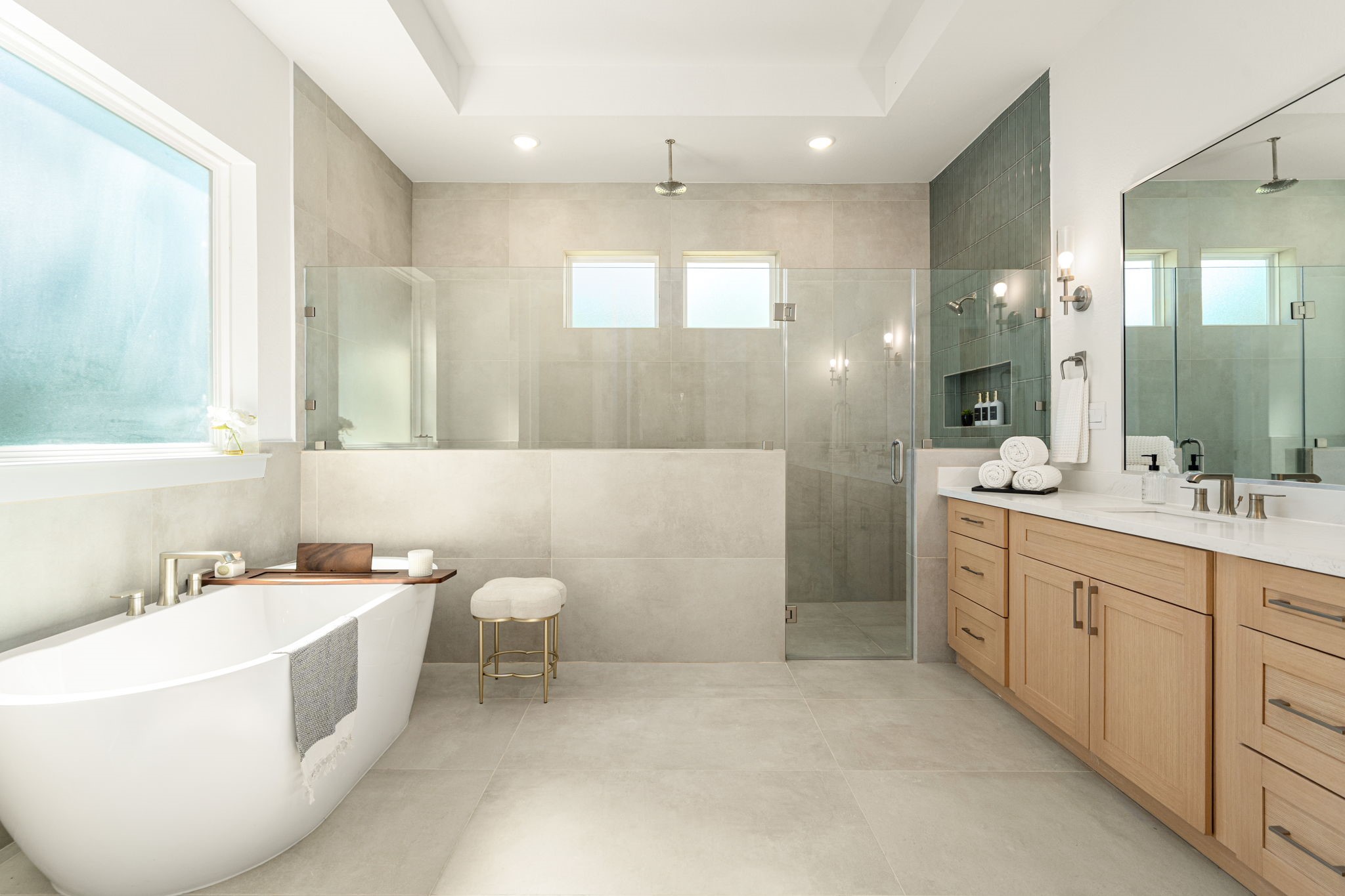 Spa-inspired primary bathroom featuring a freestanding soaking tub, expansive vanity, and elegant finishes.