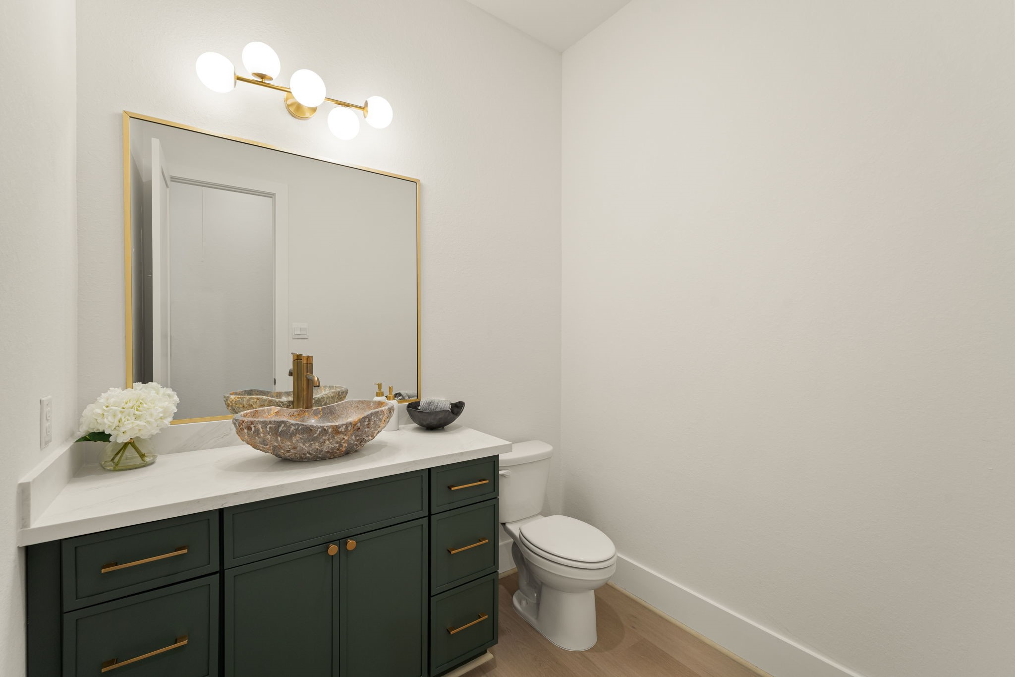 Stylish powder bathroom showcasing a beautiful vanity, modern fixtures, and elegant finishes.