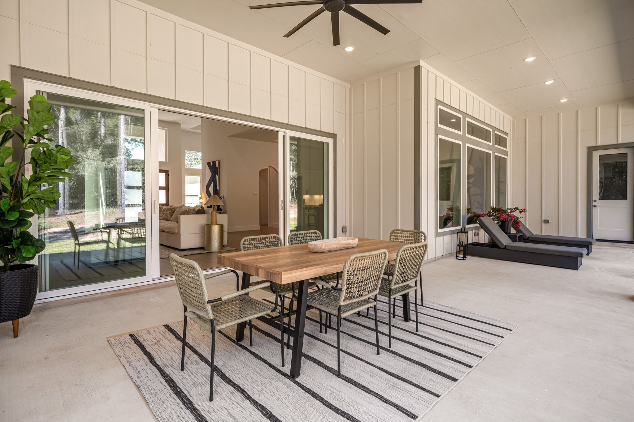 Exceptional covered patio featuring a vaulted ceiling, ceiling fans, and comfortable space for outdoor dining.