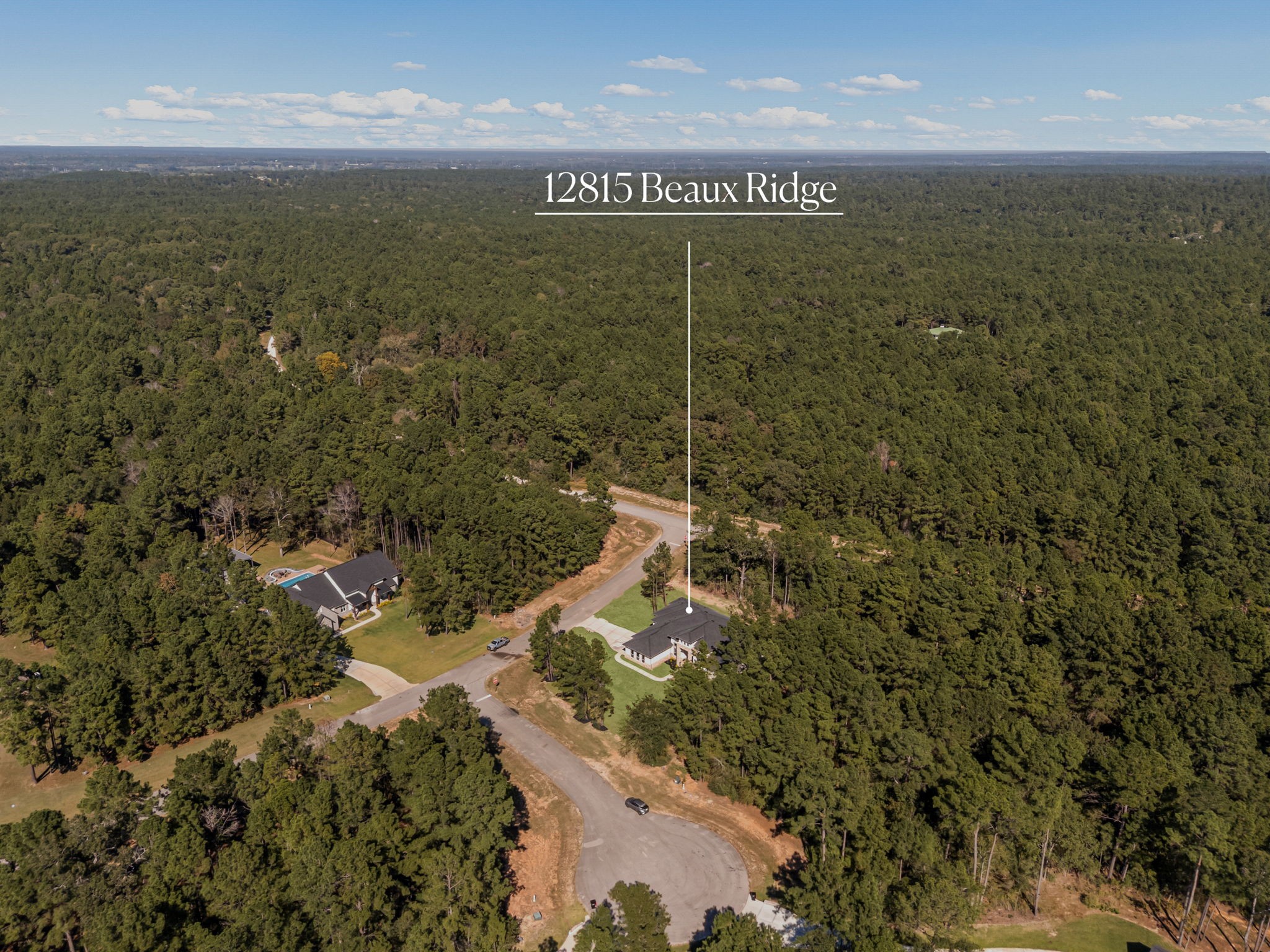Aerial perspective of the scenic Crown Ranch community and surrounding wooded landscape.
