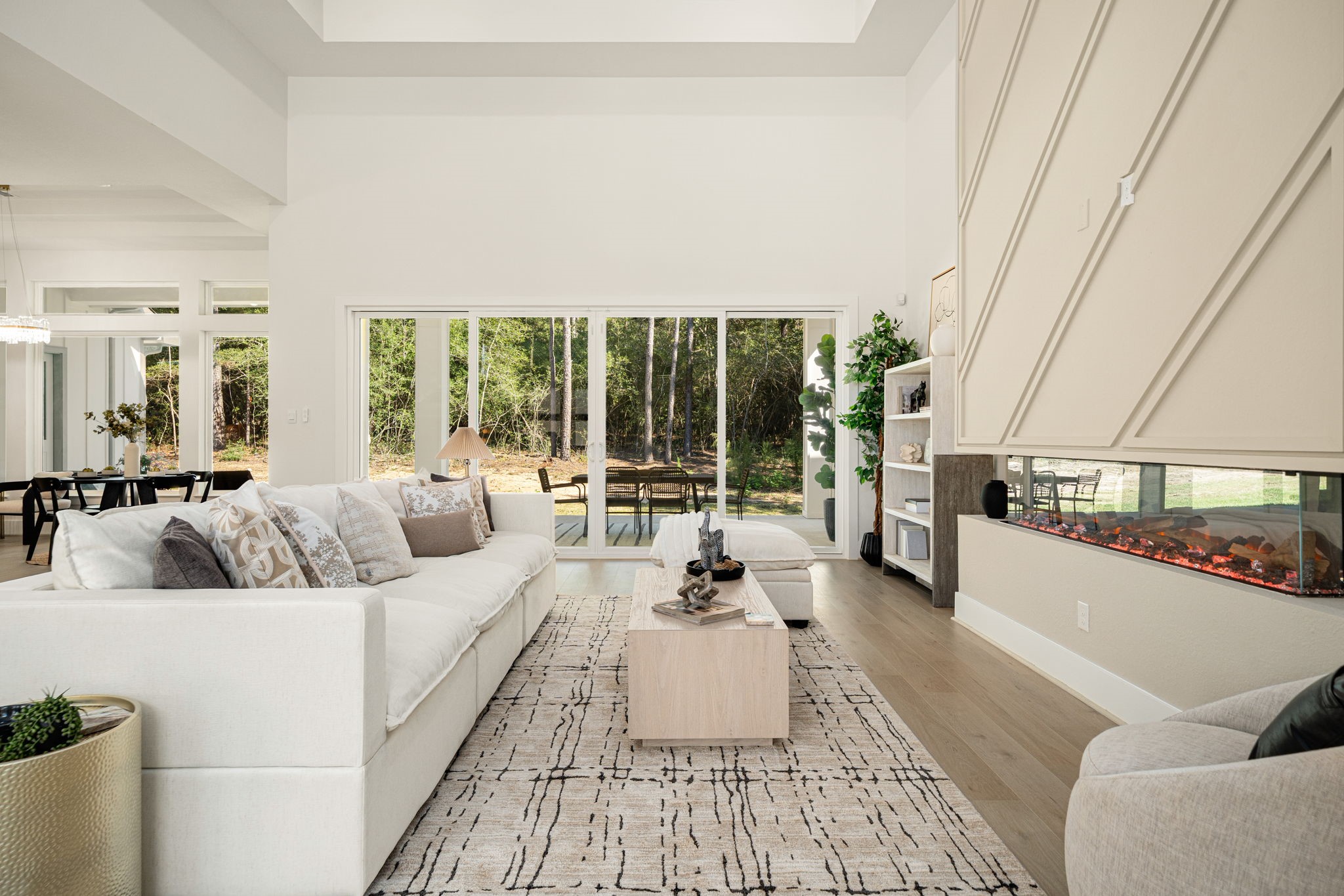 Expansive living room with dramatic ceiling details, oversized windows, and seamless access to the outdoor living spaces.