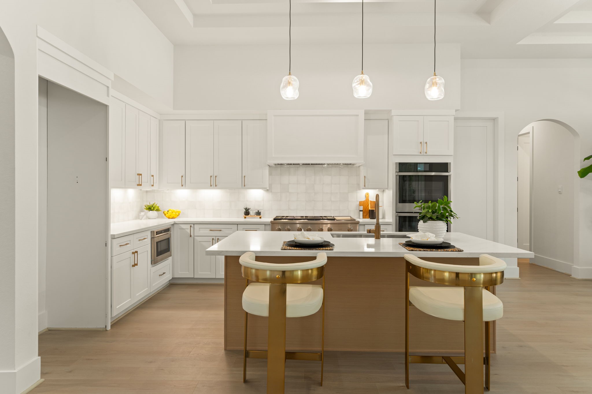 Gorgeous chef-inspired kitchen featuring an oversized island, stylish pendant lighting, and custom cabinetry.