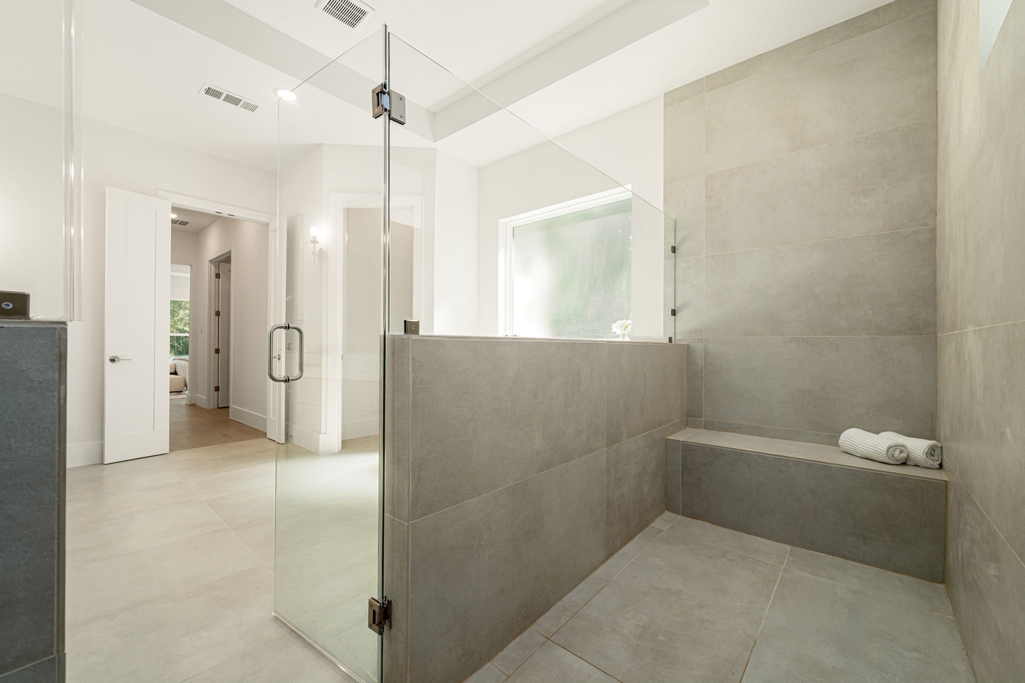 Oversized walk-in shower featuring contemporary tilework, glass enclosure, and sophisticated finishes.