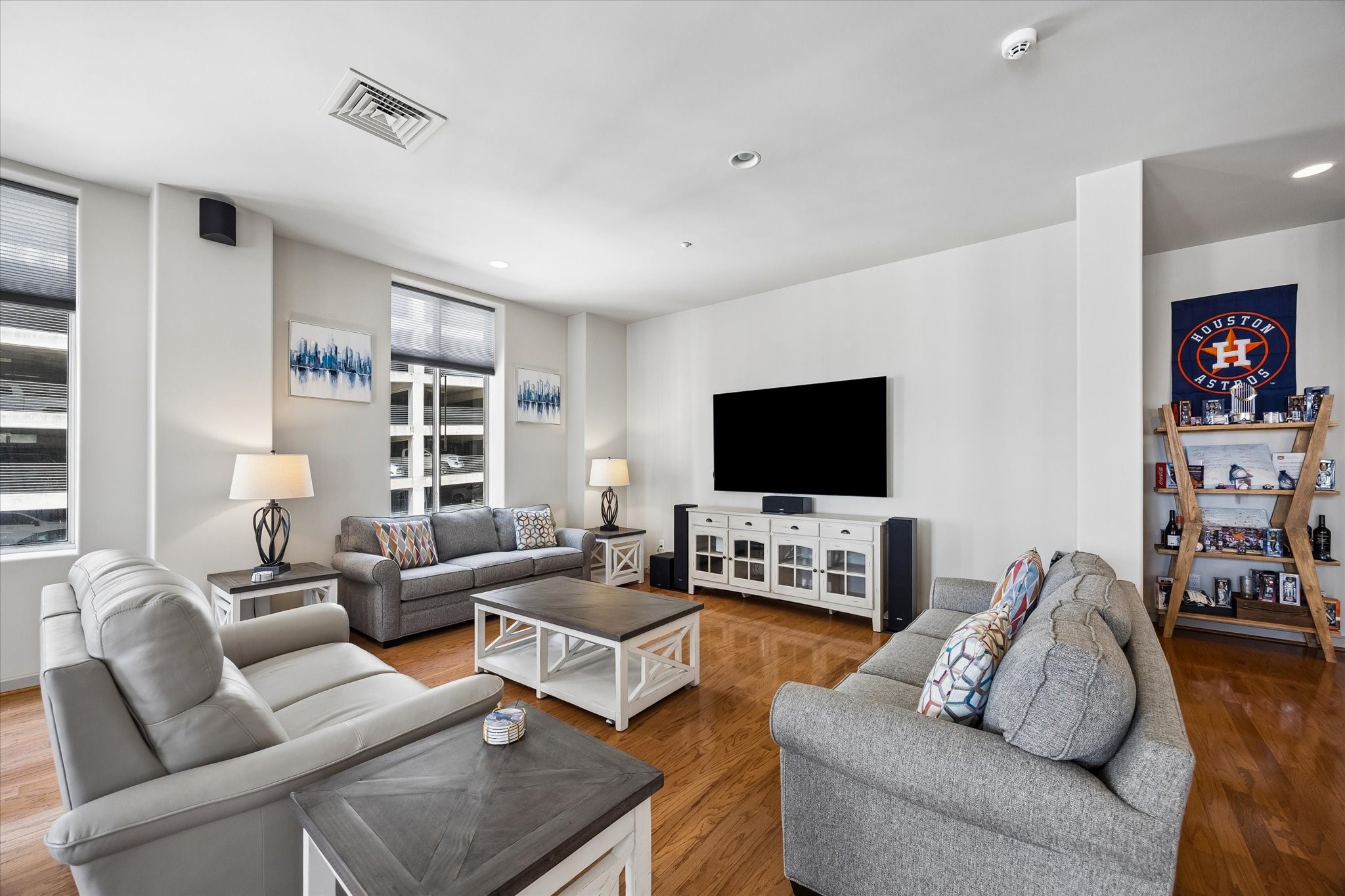Spacious living room featuring sleek hardwood floors, comfortable seating, and a large wall-mounted TV, perfect for relaxation and entertainment. Spacious living room featuring sleek hardwood floors, comfortable seating, and a large wall-mounted TV, perfect for relaxation and entertainment.