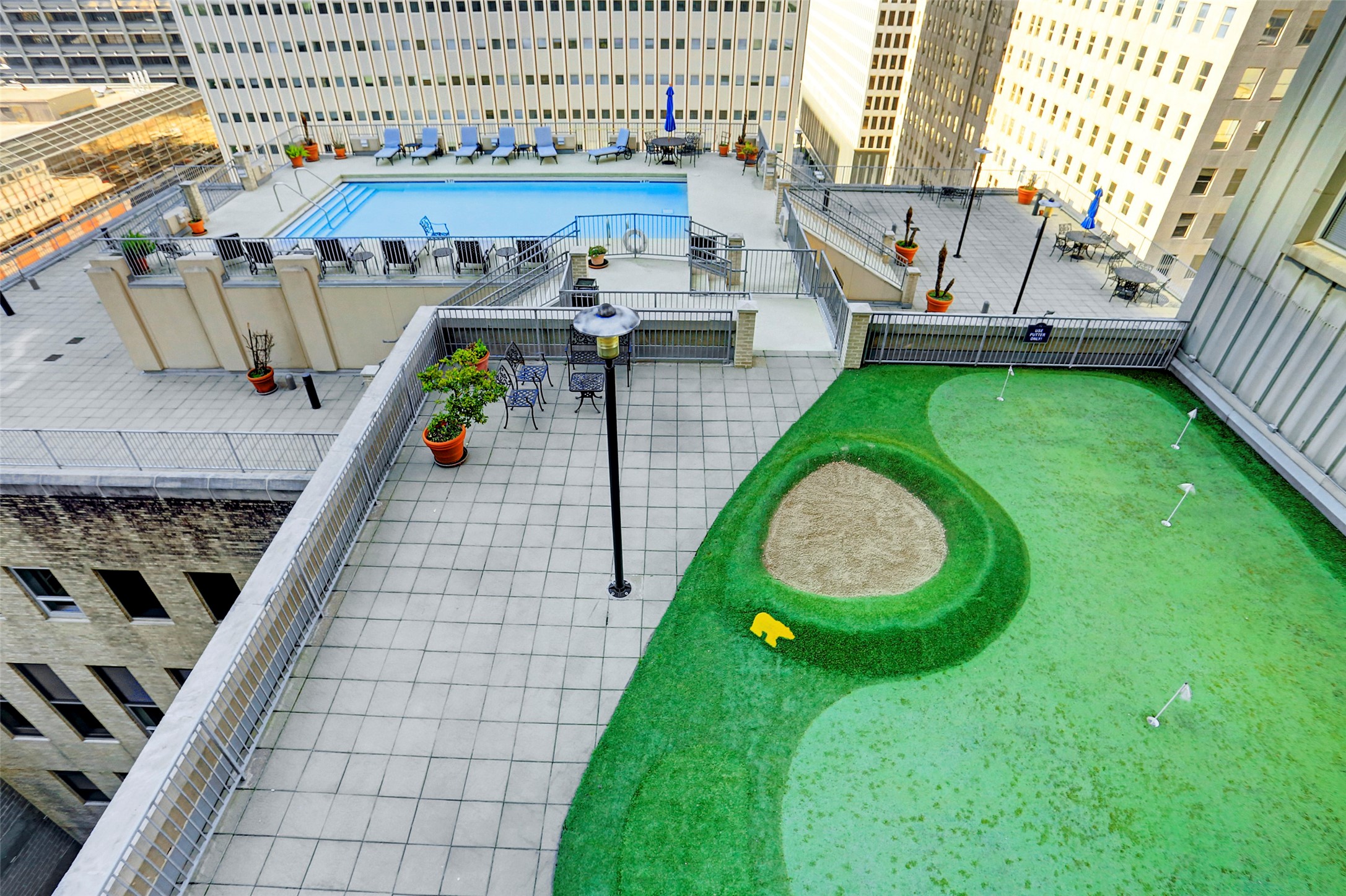 Enjoy the luxury of a rooftop oasis featuring a sparkling pool and a putting green, perfect for relaxation and recreation with stunning city views.