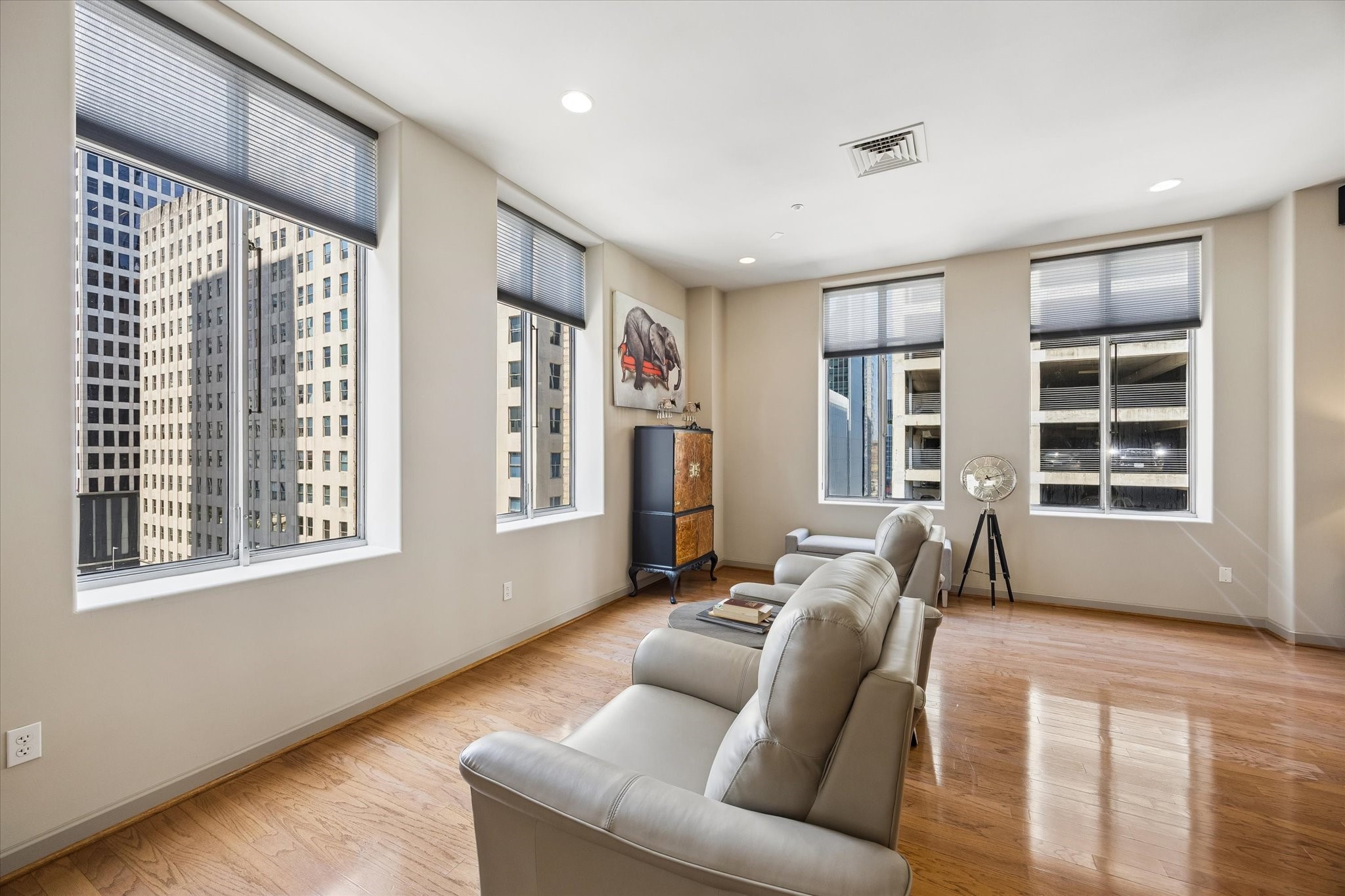 Spacious living area with abundant natural light from large windows offering stunning city views, complemented by stylish hardwood floors and modern furnishings. Spacious living area with abundant natural light from large windows offering stunning city views, complemented by stylish hardwood floors and modern furnishings.