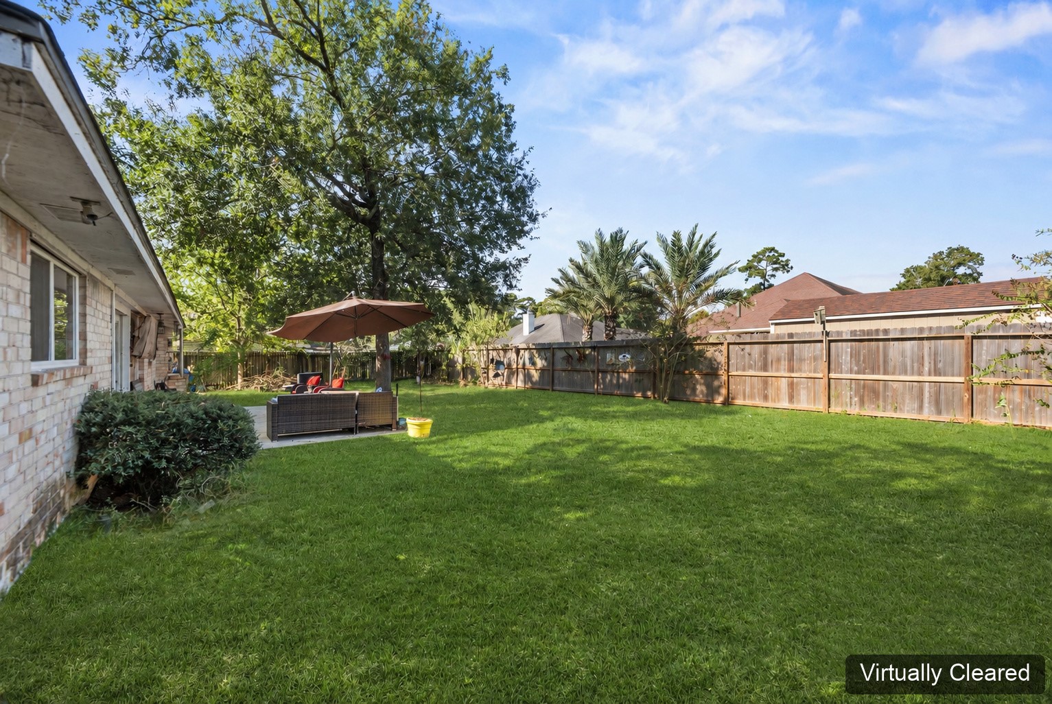 Virtually cleared side view of the backyard, showing the lawn, trees, and existing fence. The original photo at the end shows existing yard features.
