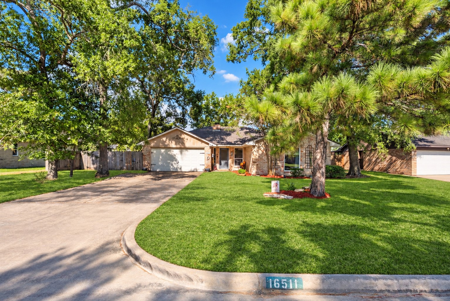 Street view of the home, front lawn, and curved curb. Temporary driveway items have been digitally cleared. Street view of the home, front lawn, and curved curb. Temporary driveway items have been digitally cleared.