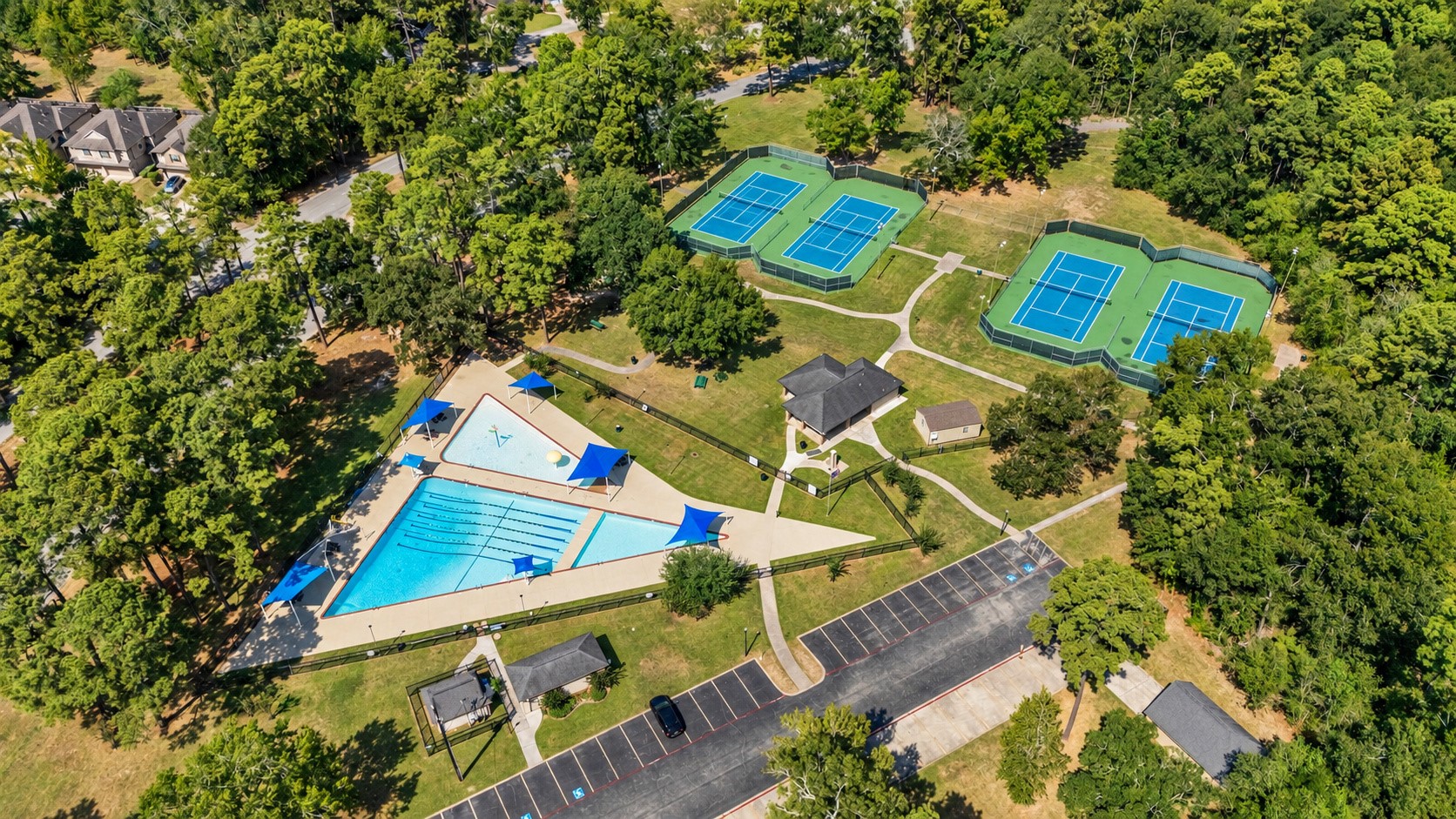 Aerial view of the Newport community pool and tennis courts, showing the surrounding recreation area.