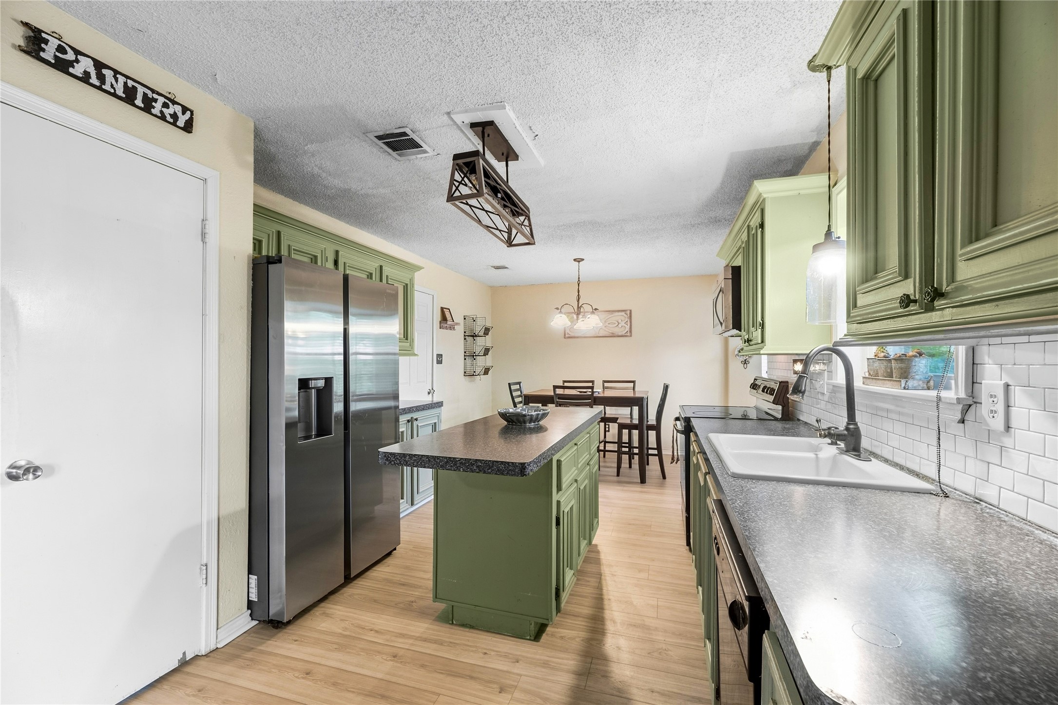 Kitchen view showing the center island, counter space, and cabinetry on both sides.