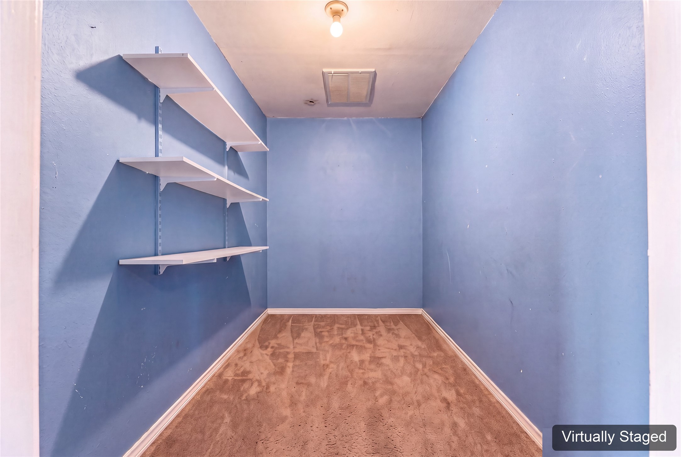 Virtually cleared bonus storage room inside the garage, connected to the home's HVAC. A useful conditioned space for extra pantry supplies, seasonal items, or belongings you prefer to keep out of garage heat. Original photo at the end shows the existing contents.