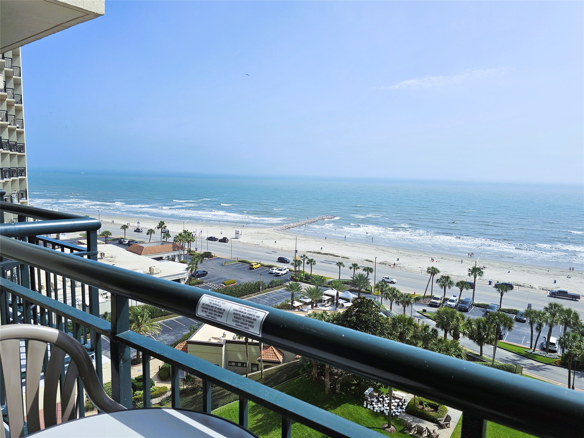 Experience breathtaking ocean views from this balcony, overlooking a serene beach and vibrant coastal scenery.