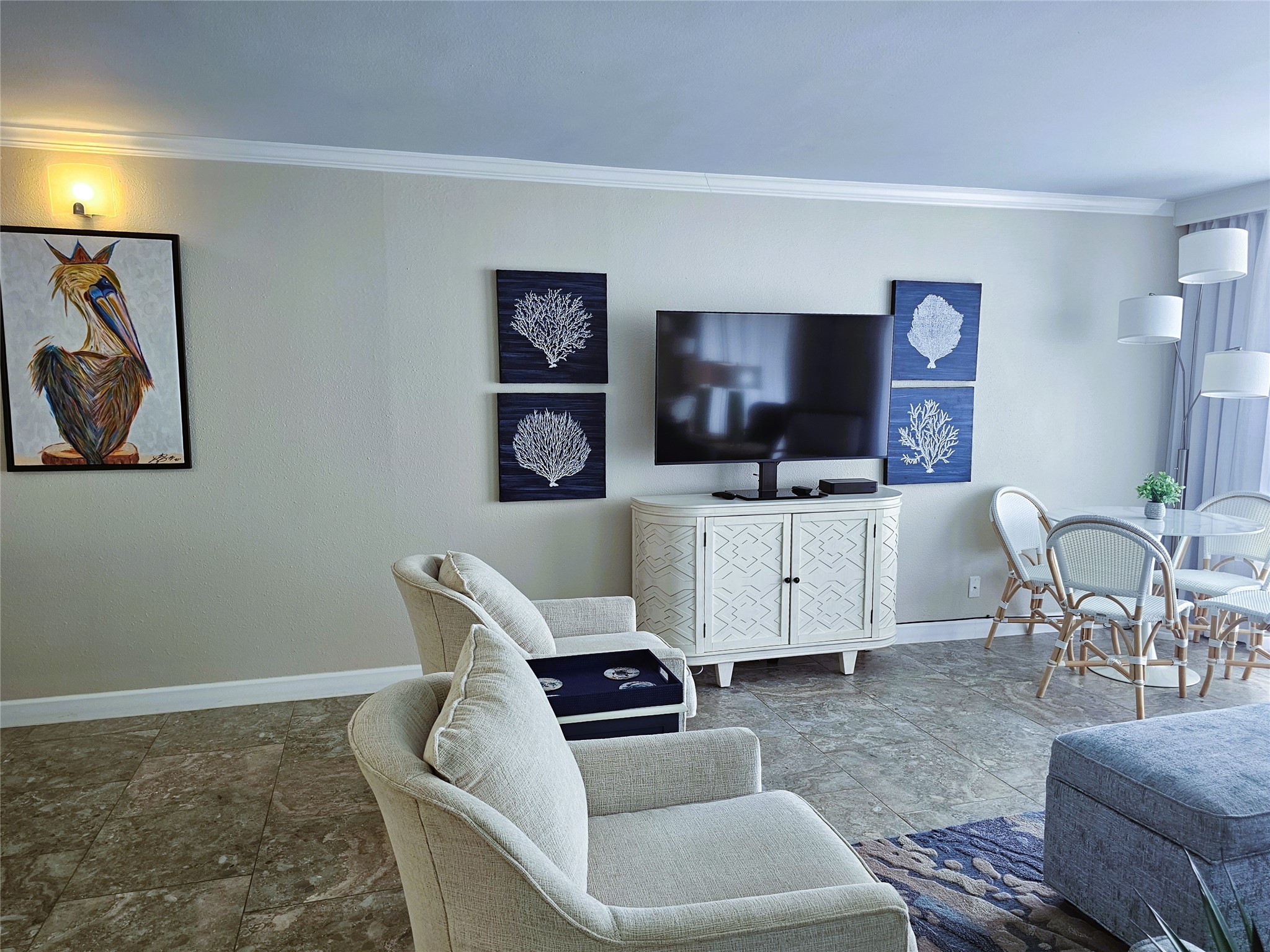 Bright and inviting living space with modern decor, featuring a wall-mounted TV, stylish artwork, and a cozy seating area, perfect for relaxation and entertainment.