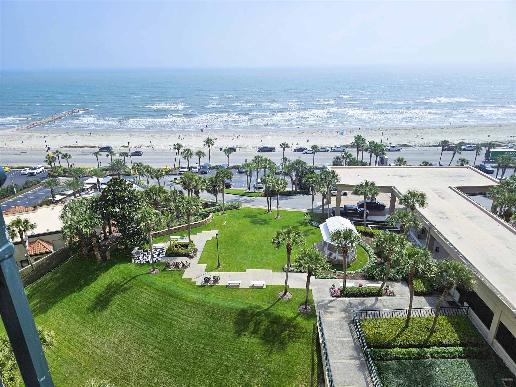 Enjoy breathtaking ocean views from this elevated perspective, featuring lush green lawns and swaying palm trees, all within a short stroll to the sandy beach.